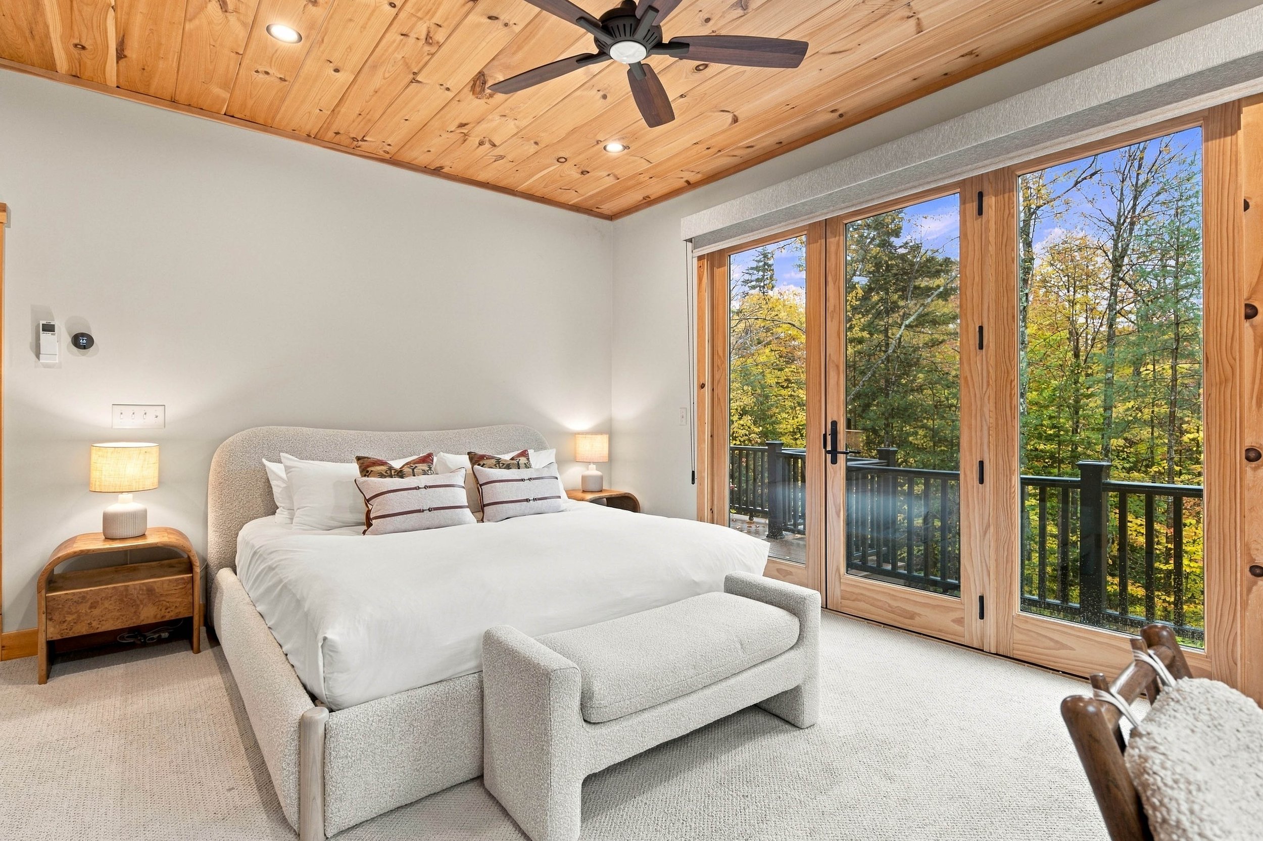 Relax in the main-level primary king suite, featuring a private ensuite bathroom and peaceful woodland views.