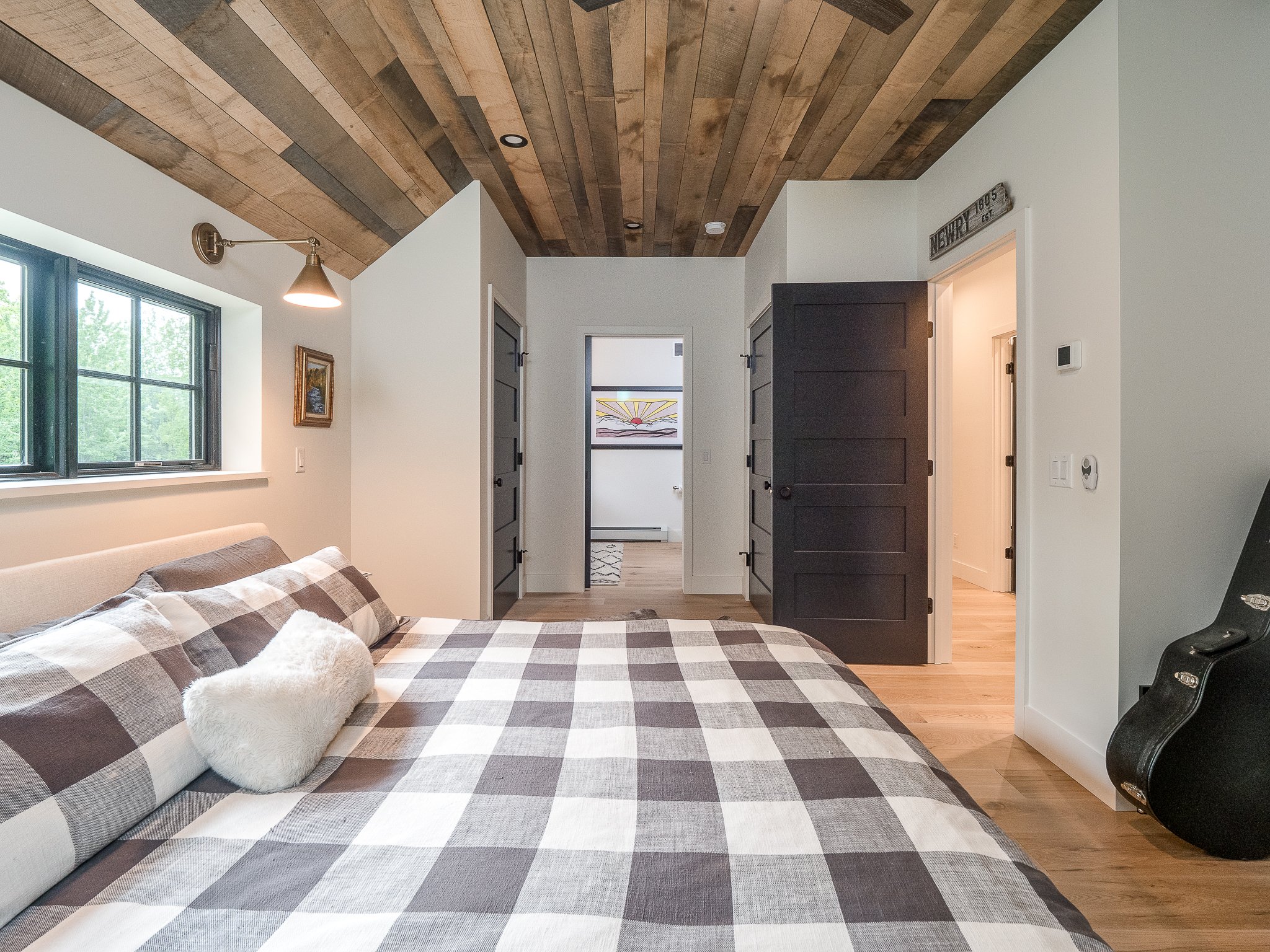 Modern bedroom with wooden ceiling and plaid bedding
