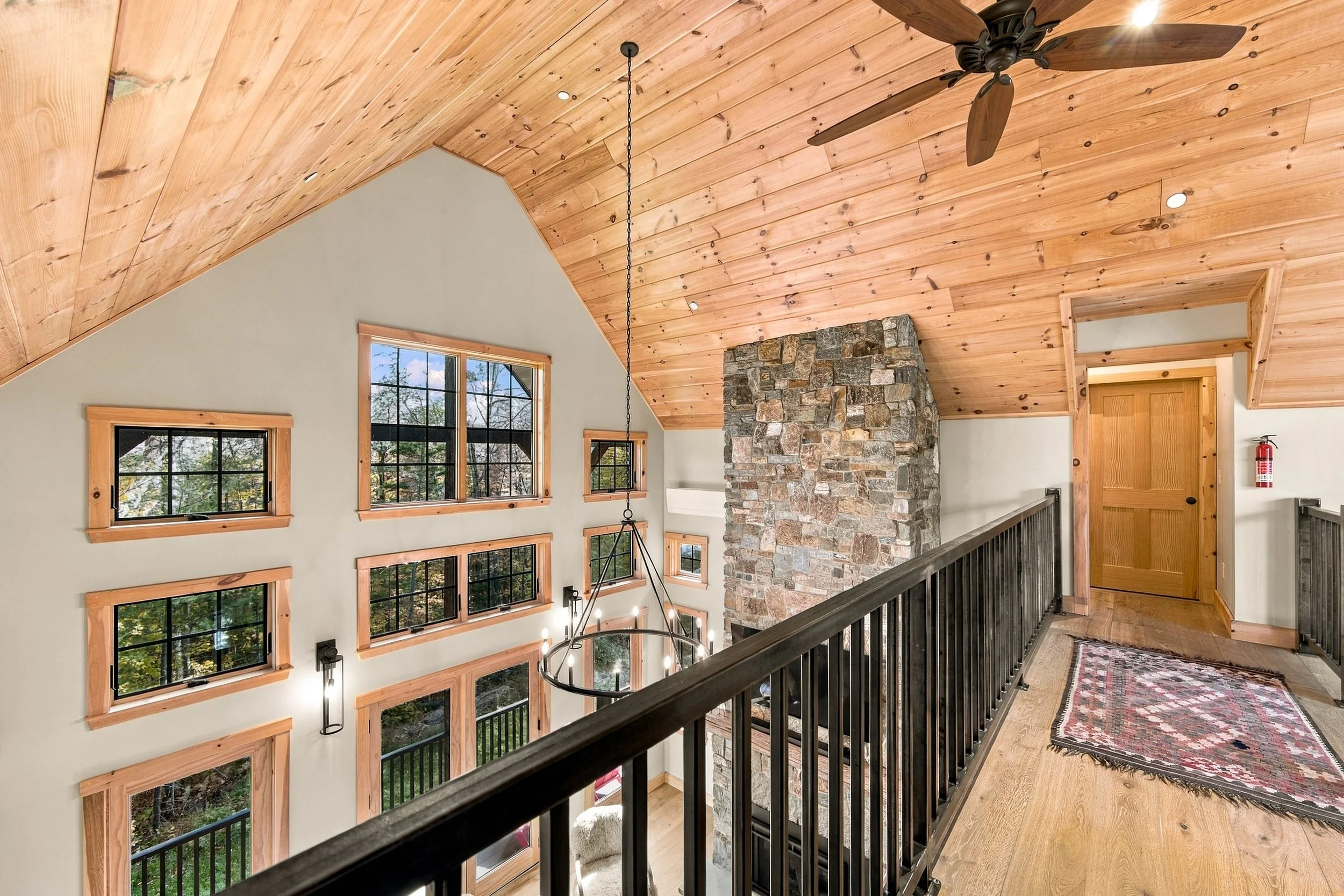 An impressive view from the upper-level landing showcases the home's beautiful wood ceilings and grand architecture.