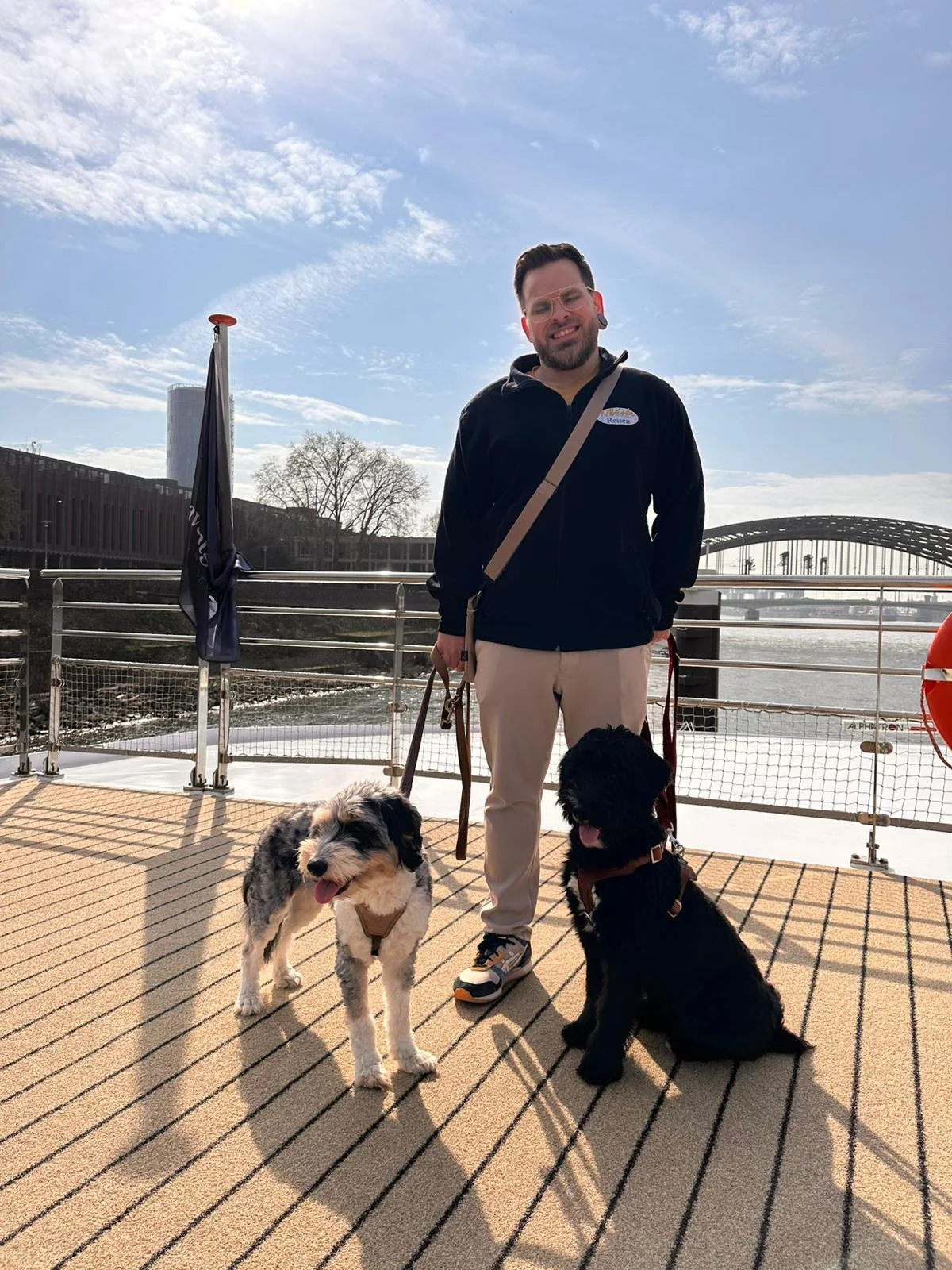Mann mit zwei Hunden an Deck eines Kreuzfahrschiffes