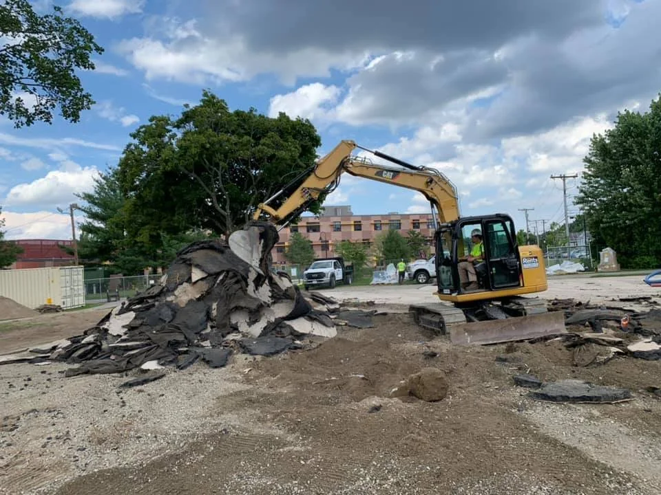an excavator works on demolition of the site where a new playground will be installed 