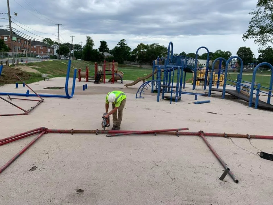 A construction worker is building a new swing set to be installed in a playground 
