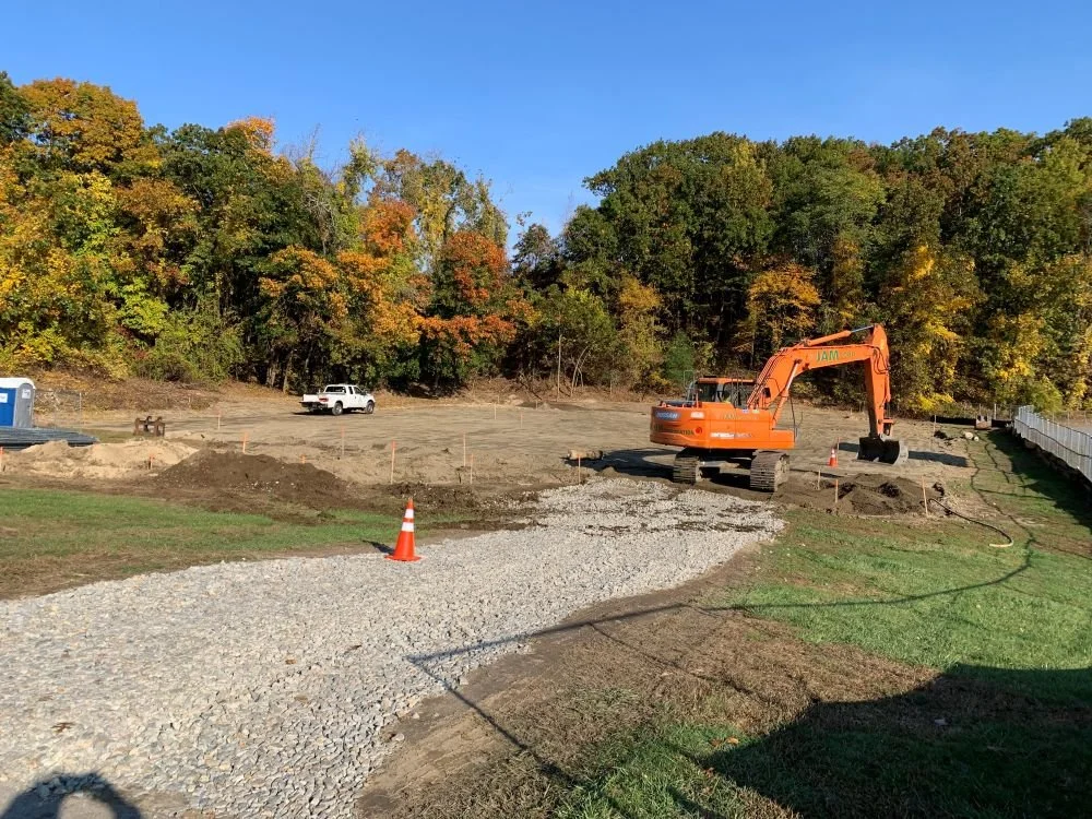 an excavator sits on the land where a new park will be installed in the town of Stow, MA.