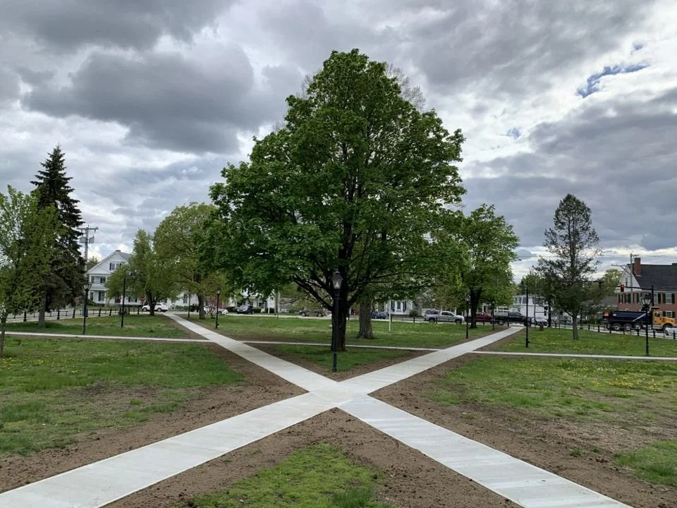 The Townsend Commons municipal project has been completed and a new walkway now crosses through the park in an "X" shape with trees dotted throughout the park.