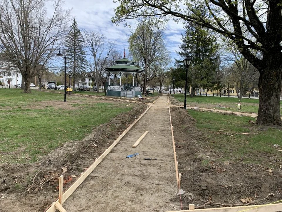 In the center of the image a newly dug and levelled path through the center of Townsend Common has been prepared for new concrete to be poured. 