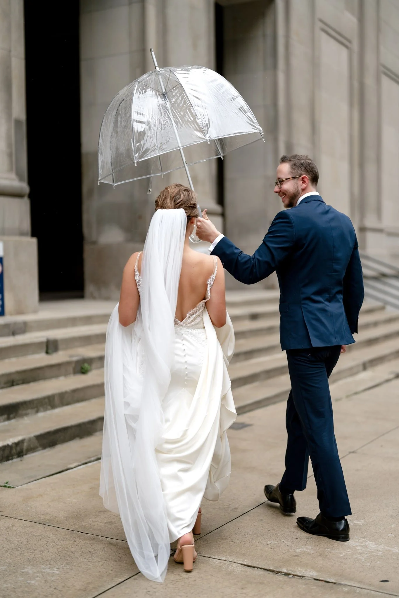 Couple heading up stairs with umbrella to protect from the rain