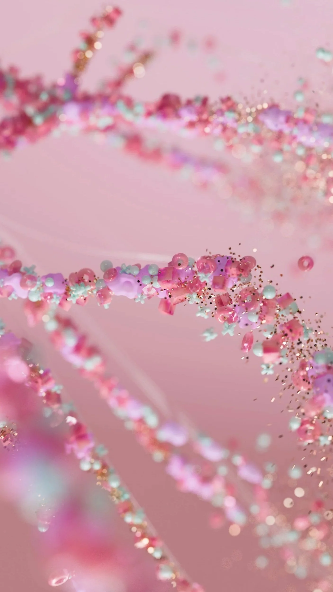 Close-up of tiny decorative beads and glitter on a pink background.