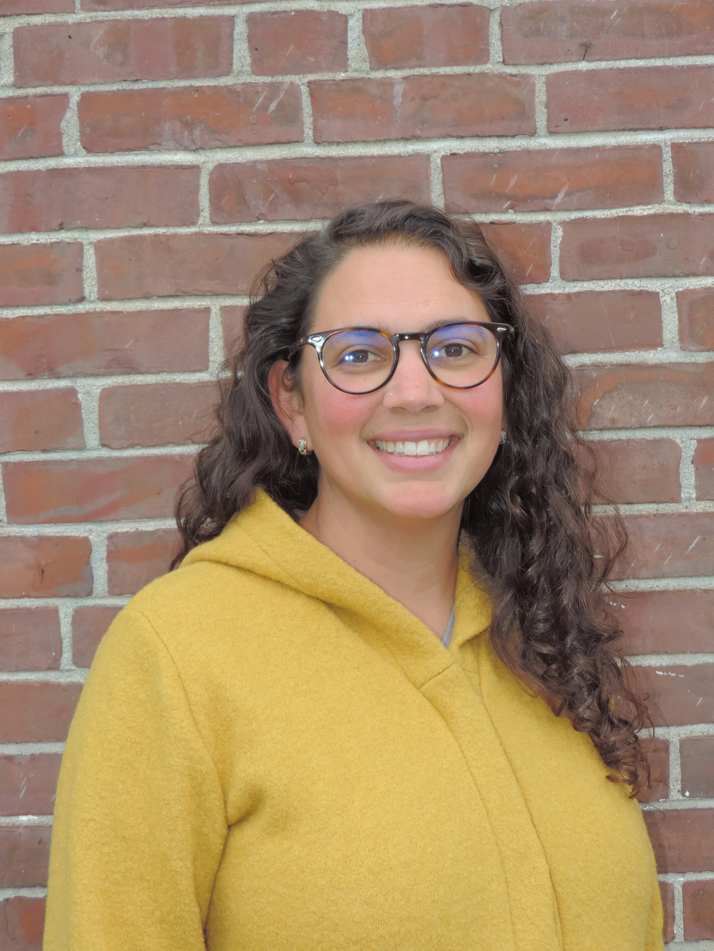 Smiling woman and child surrounded by lush green leaves.