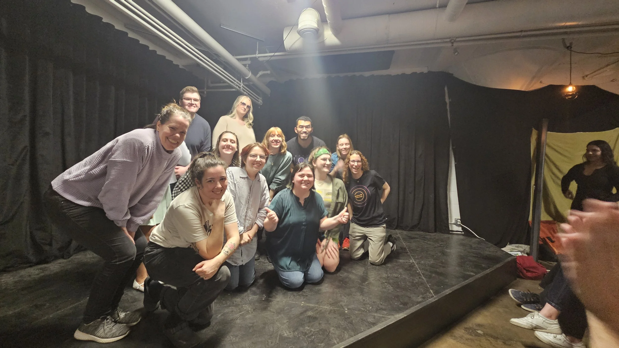 Photo of improvisers of all levels, beginner and advanced players, smiling after a successful improv set!