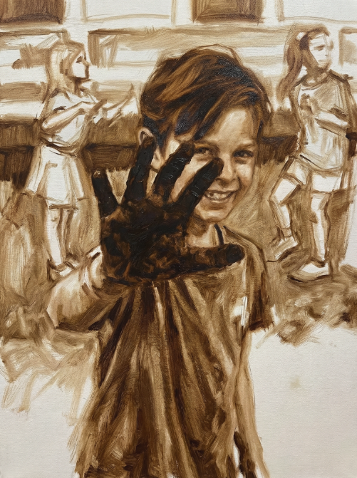 A young boy with a big smile holding up his hand adorned with a black glove, with paralyzed or excited girls in the background.