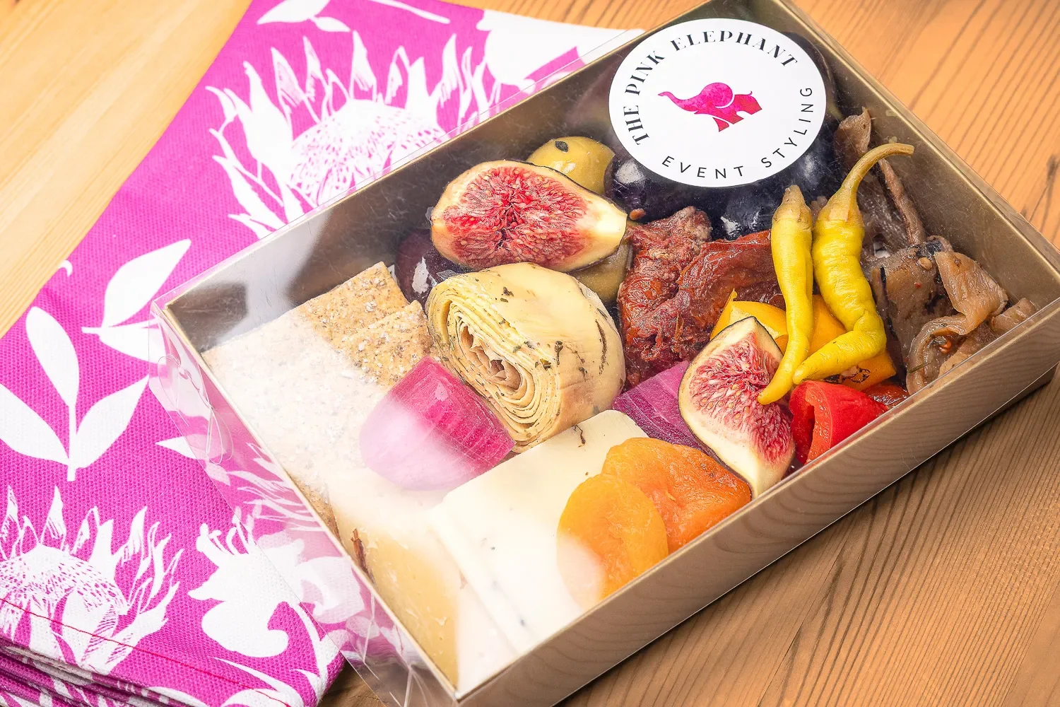 Styled product shot of Pink Elephant charcuterie tray with figs and artichoke hearts, product photographer Hertfordshire