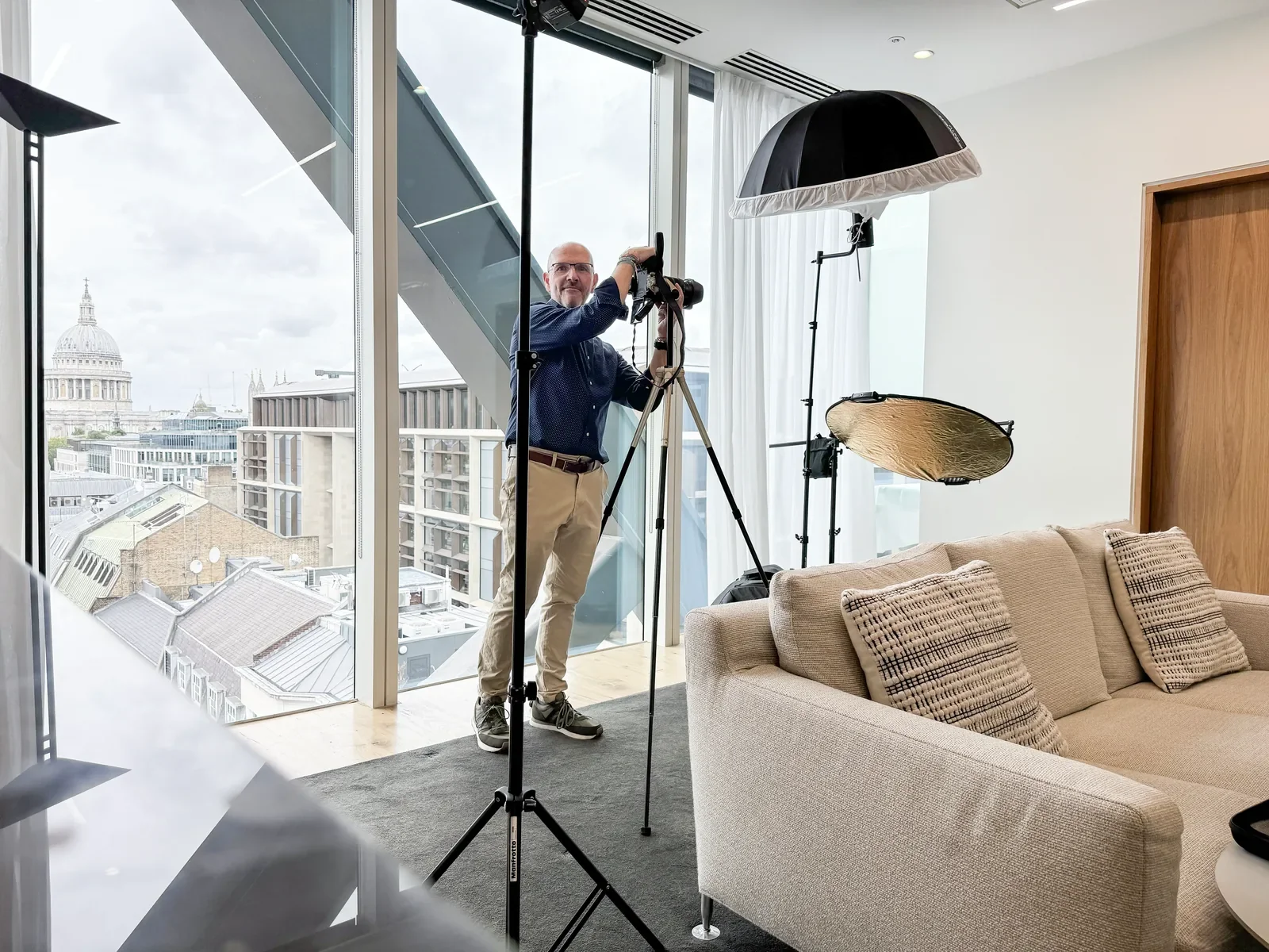 Photographer setting up lights for an executive portrait in a City of London office overlooking St Paul's Cathedral