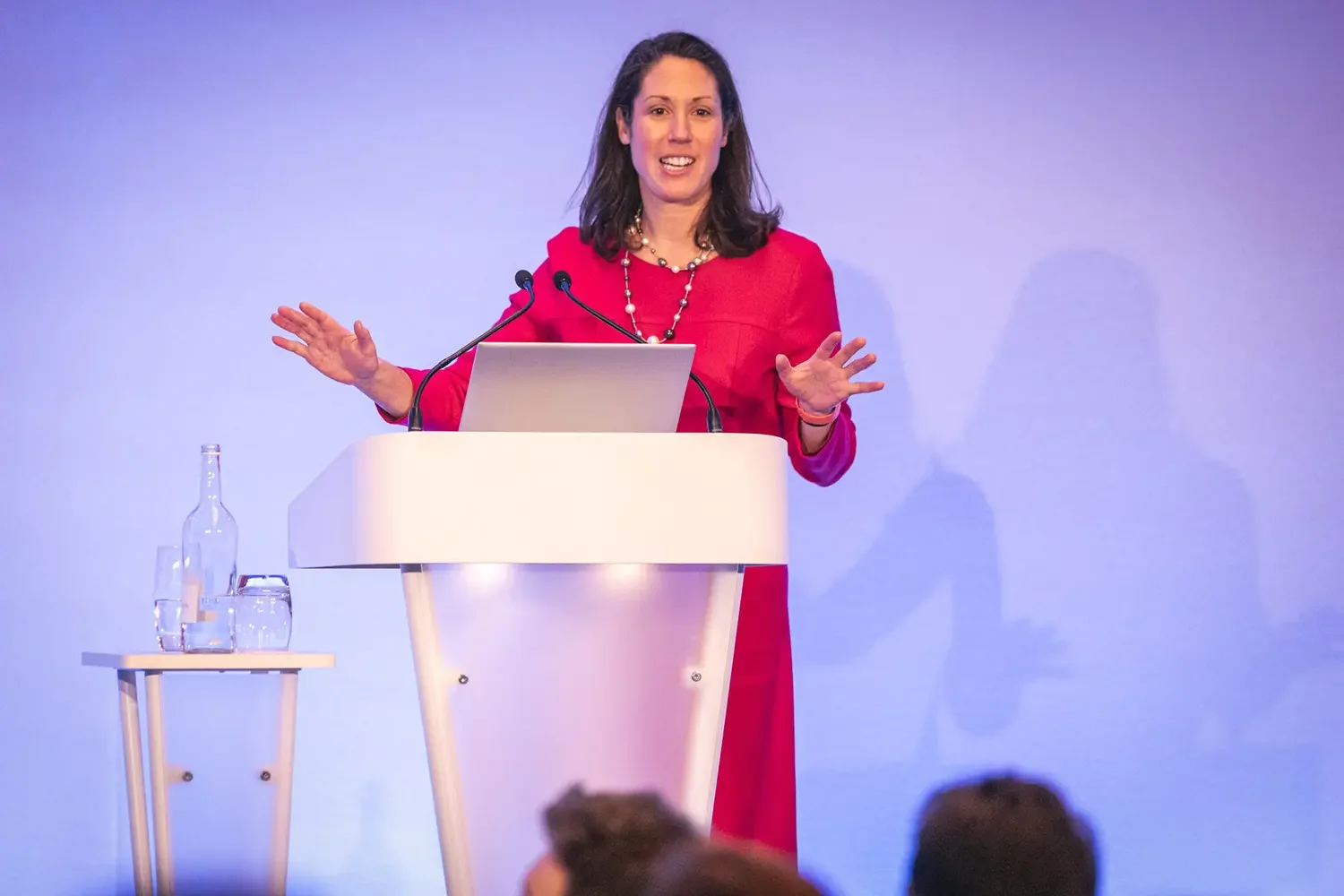 A business woman on stage presenting at an event.