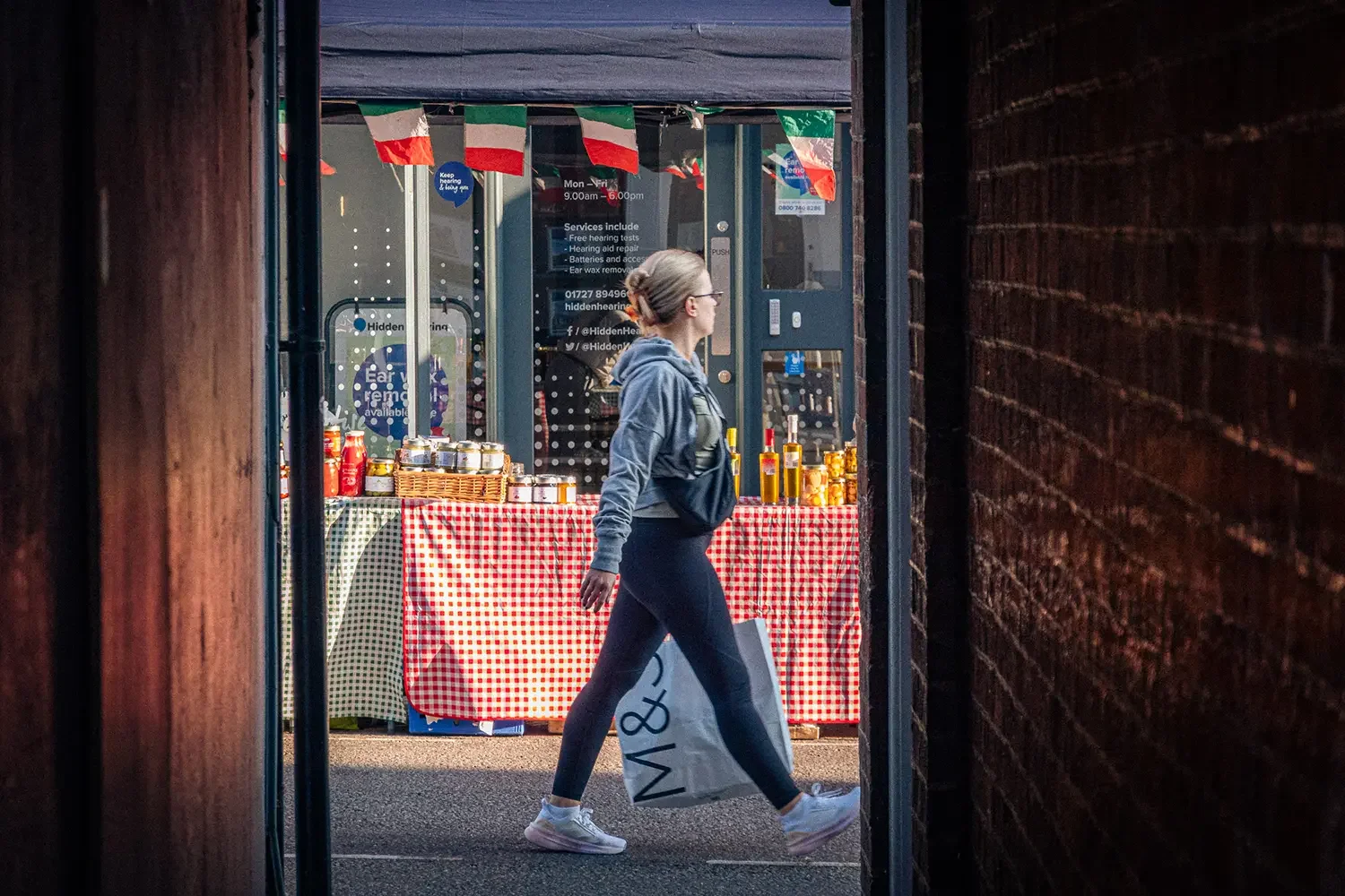 A lady walking through st Albans Market.webp