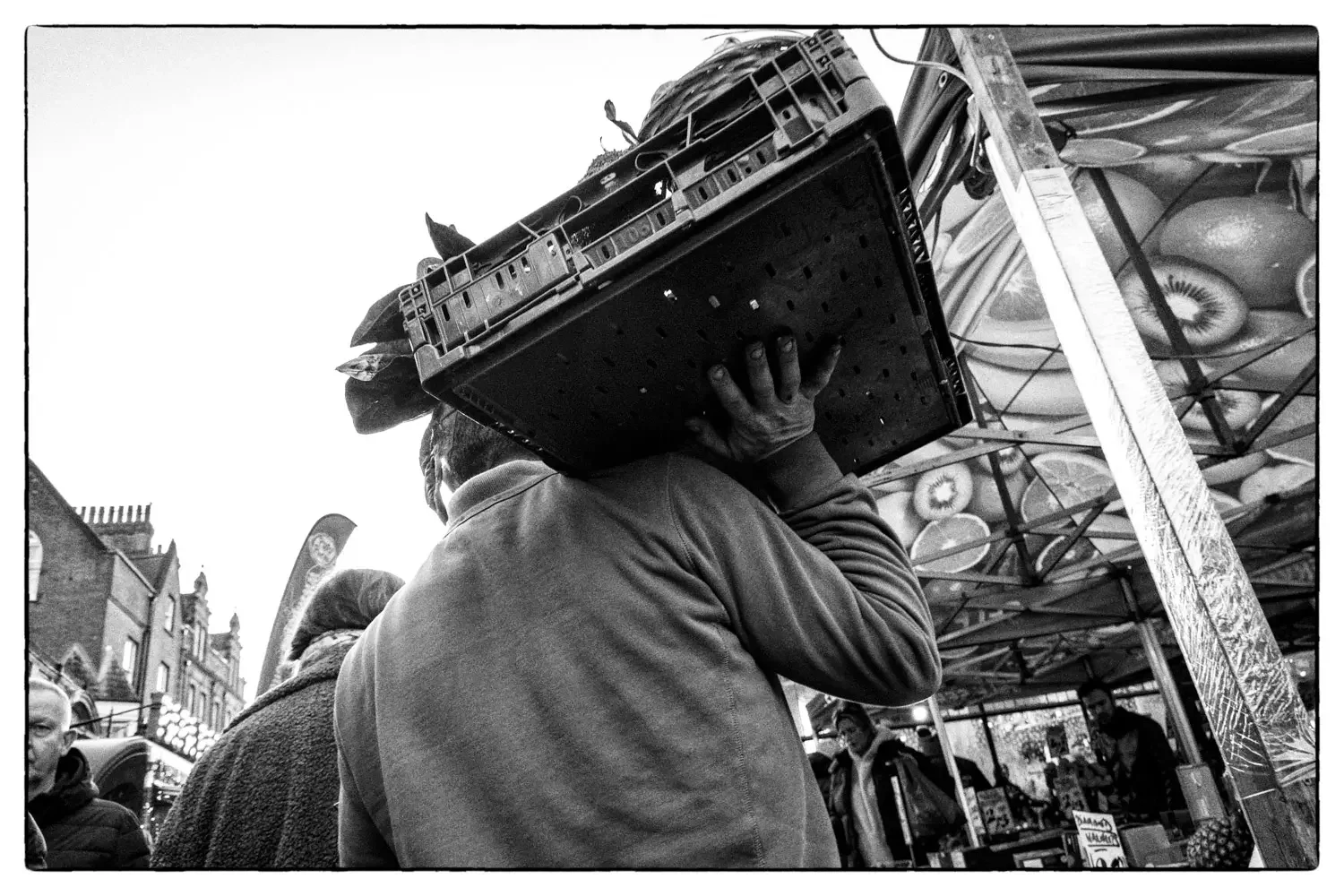 A market trader carrying fruit and veg at the St Albans Christmas market.webp