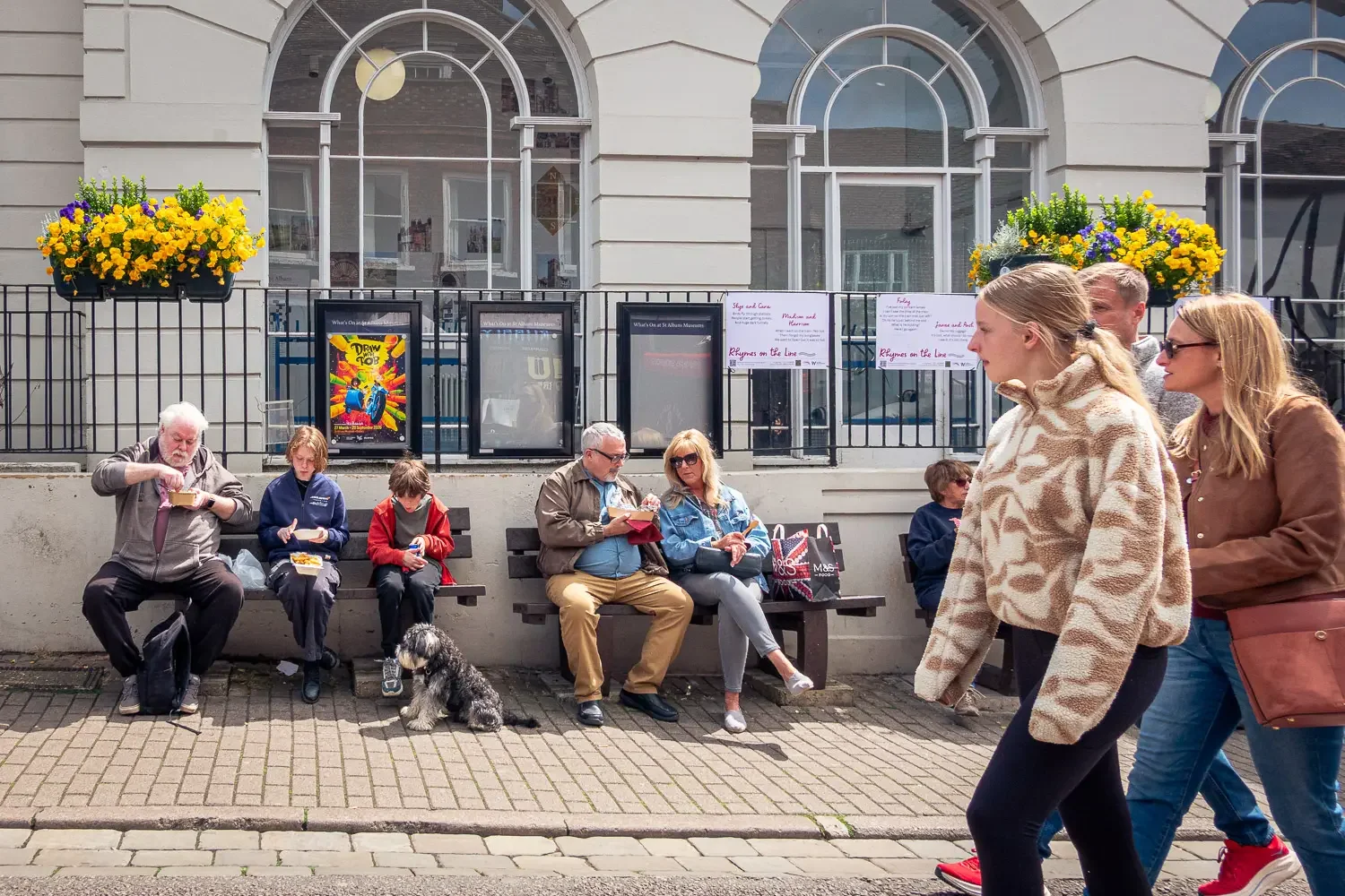 Families sitting on benches outside St Albans Museum and Gallery