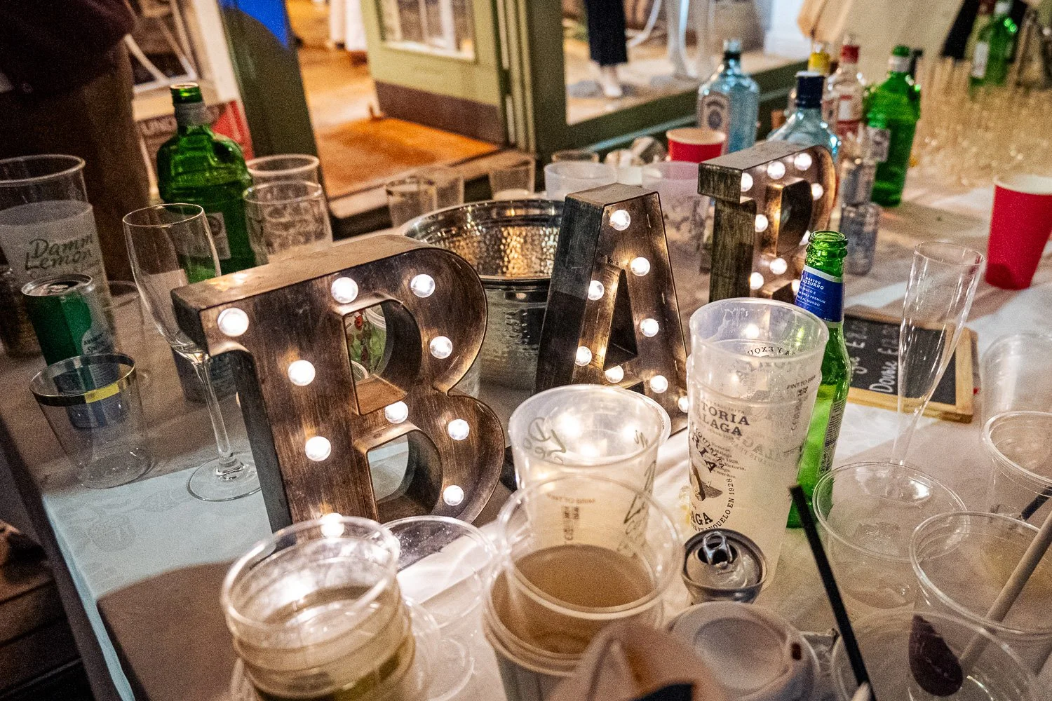 Light-up BAR letters on a drinks table lined with gin bottles at St Albans Gin and Jazz