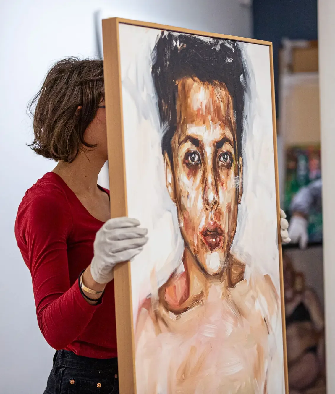 A female holding up a painting.webp