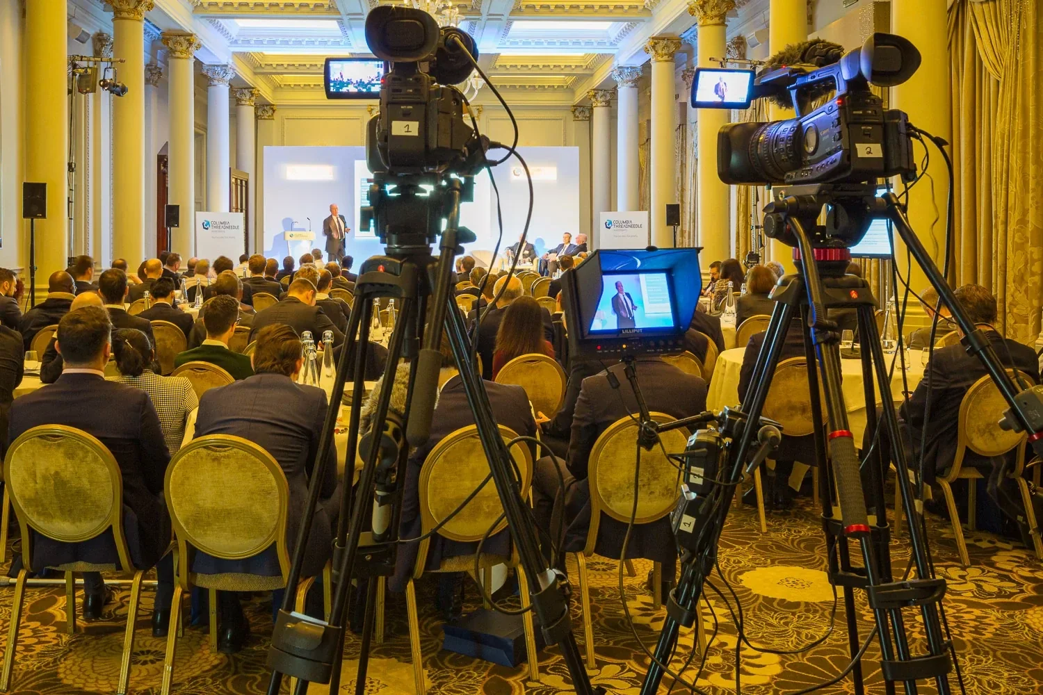 Corporate conference in a London ballroom, photographed from behind the video crew's cameras