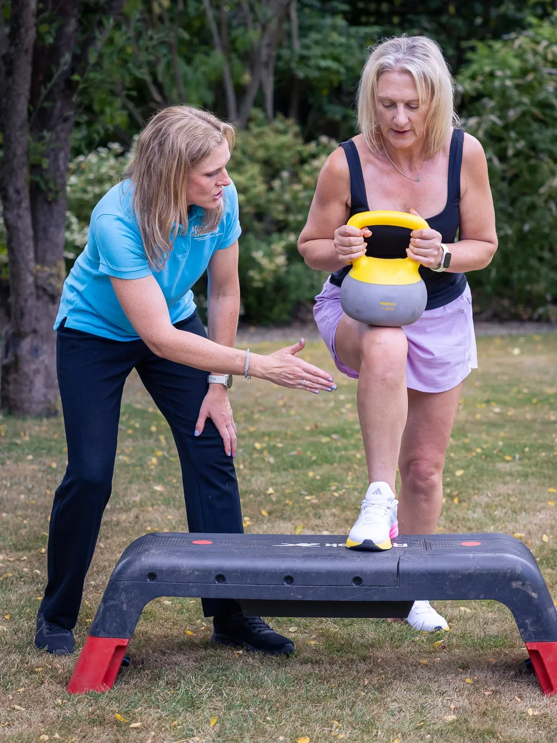 Michelle Stacey coaching a client through a kettlebell step-up exercise in Harpenden.