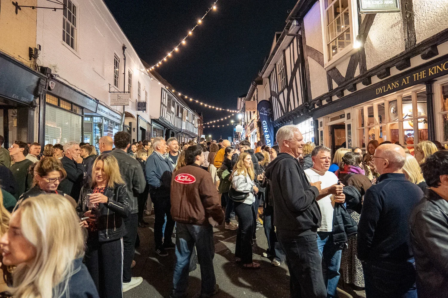 Busy George Street outside George Street Canteen at night, with festoon lights strung between the buildings