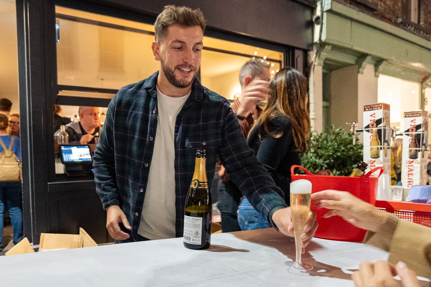 Bartender pouring prosecco at a stall outside a shop on George Street, St Albans