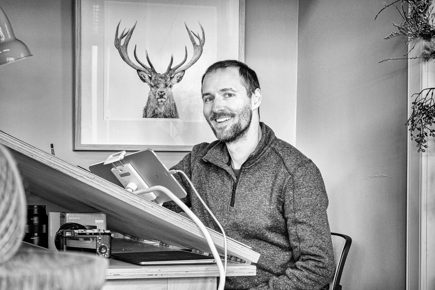 Stuart Scott, artist and owner of Sasco Art, smiling at his drawing board in his Helensburgh studio