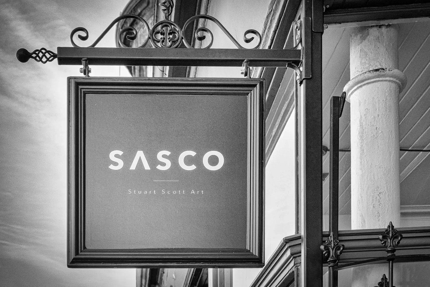 Close-up of the Sasco Stuart Scott Art hanging sign, Helensburgh — black and white photograph