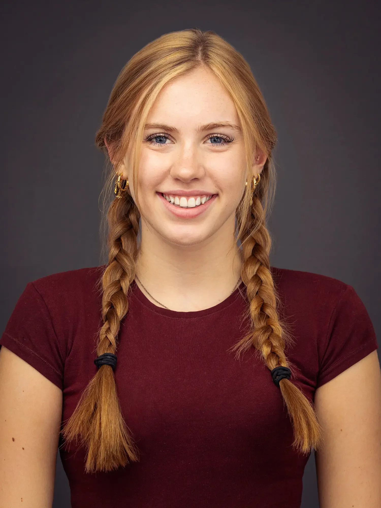 Commercial-style actor headshot with a bright natural smile and braided hair