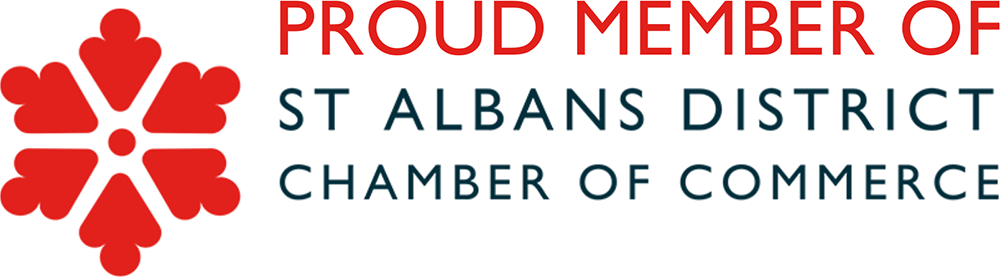 Logo with red flower-like symbol and text. The symbol has five petals with a dot in the center. The text reads: "PROUD MEMBER OF ST ALBANS DISTRICT CHAMBER OF COMMERCE".