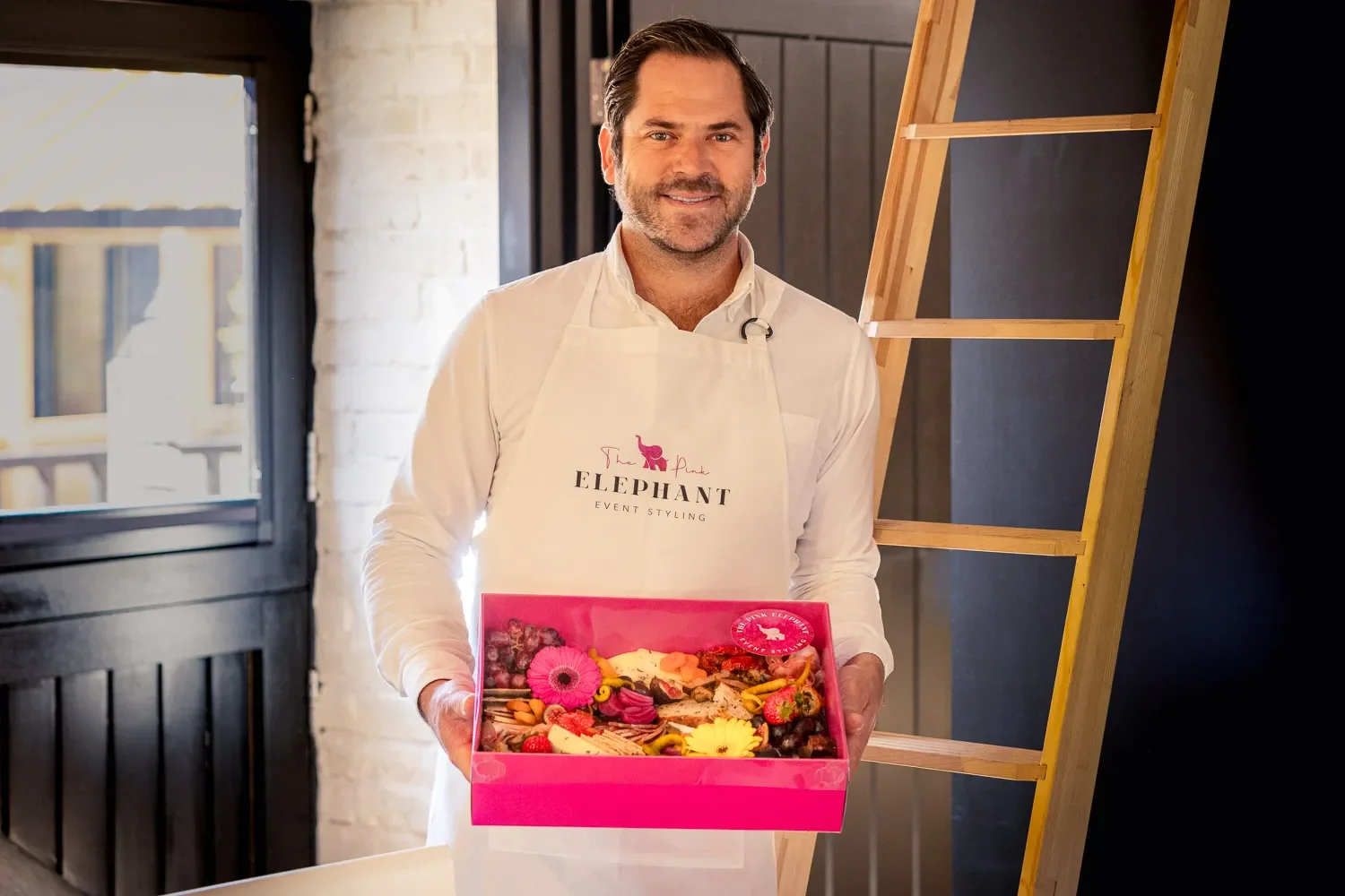 Ian Henderson of The Pink Elephant Event Styling holding a charcuterie box, personal branding portrait at OVO St Albans
