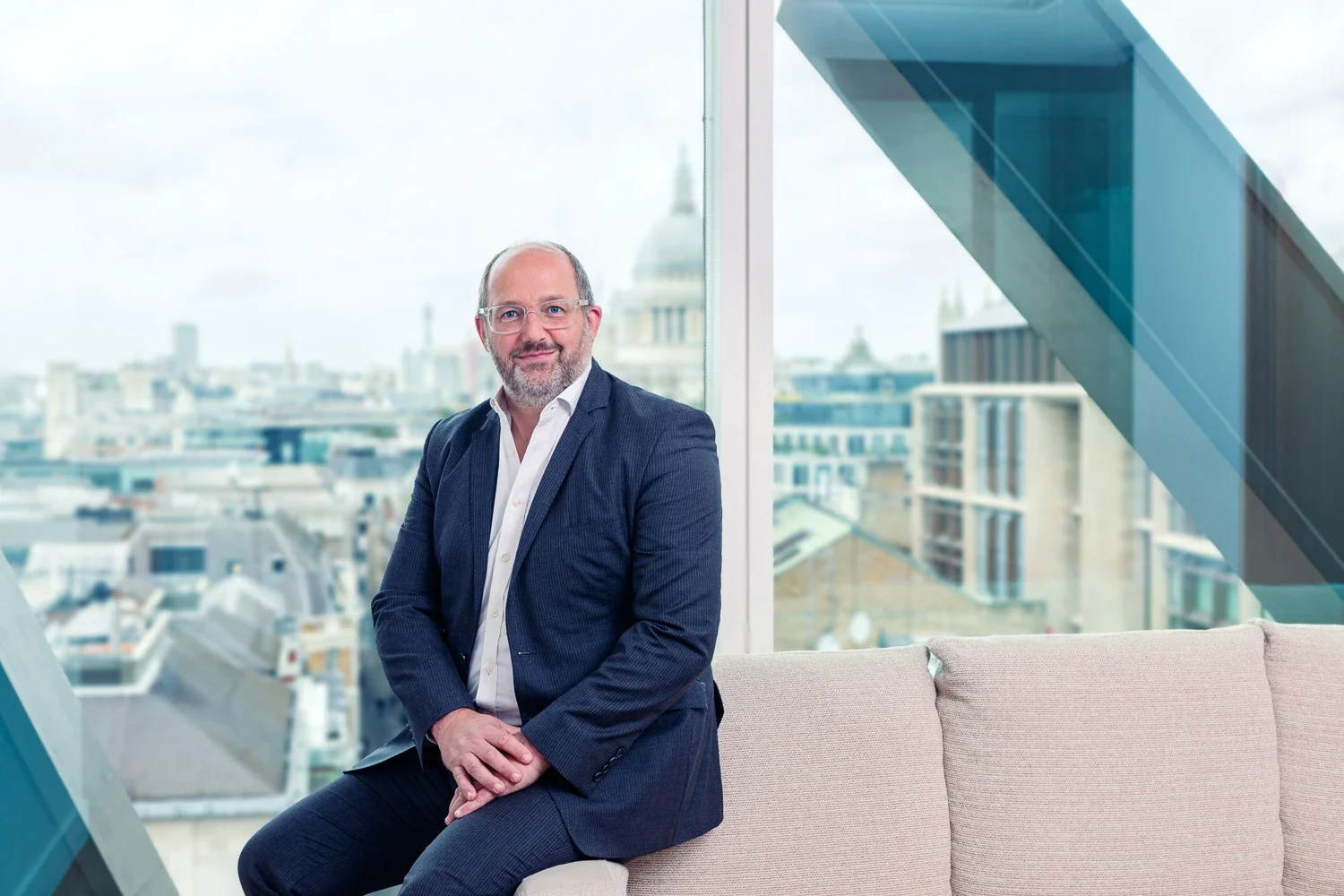 Executive portrait on a sofa beside a window overlooking St Paul's Cathedral, City of London
