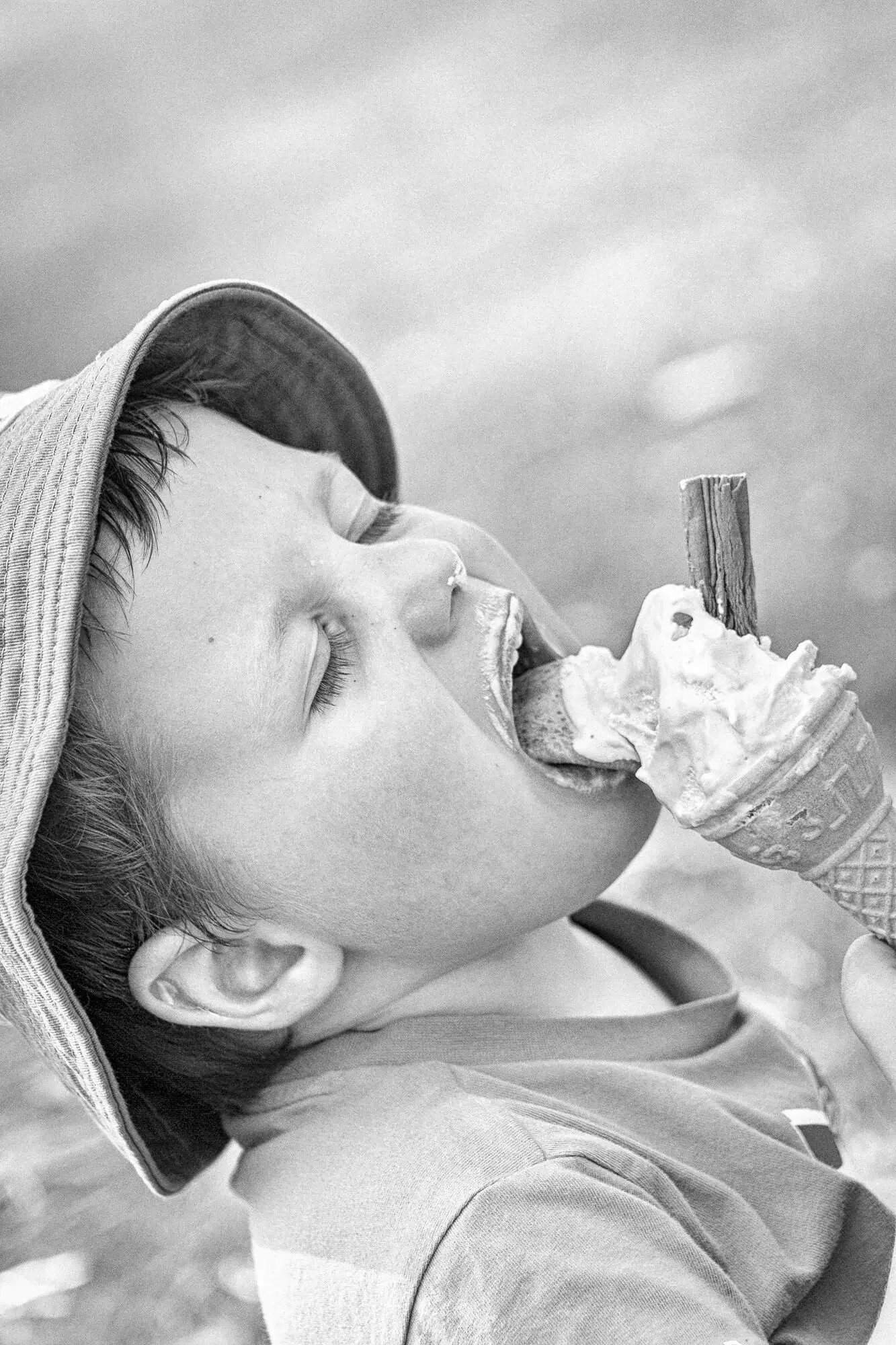A young boy enjoying licking an ice cream.