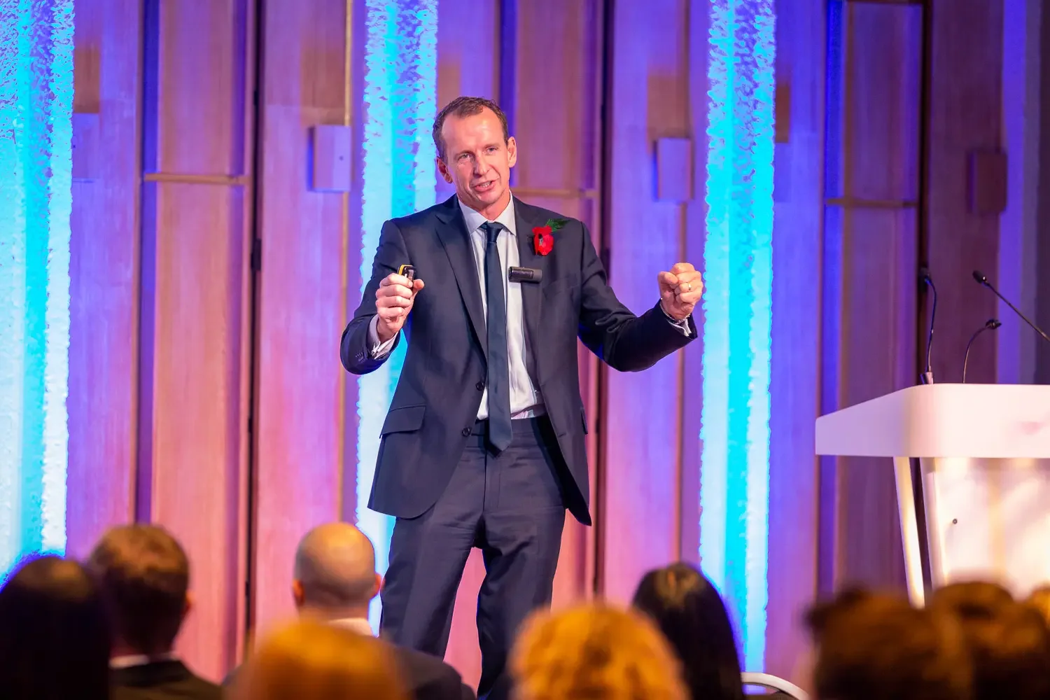 A male presenter talking to a corporate audience in an office environment.