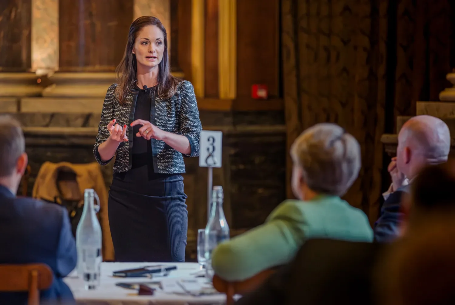 A business woman presents to a group of people at a corporate event in London.