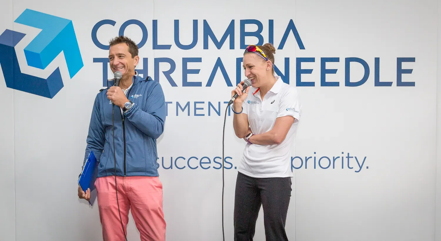 Two speakers sharing a candid moment on stage at a Columbia Threadneedle Investments corporate event in London.