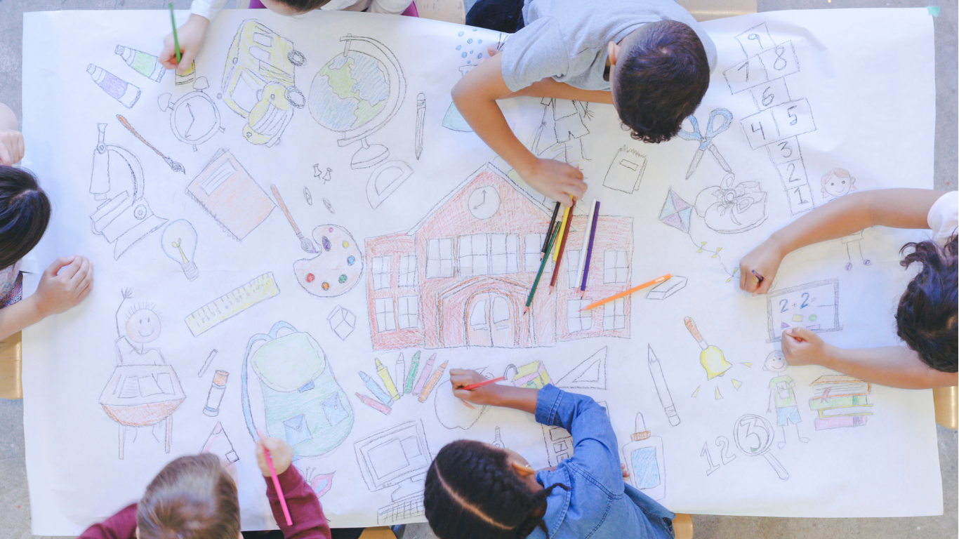 Children working together on a large sheet of paper with school-related drawings and sketches, including a school building, globe, books, science equipment, and numbers.