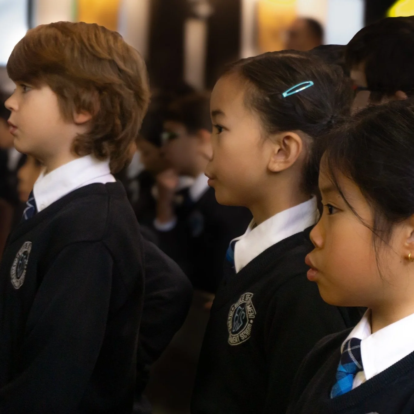 Group of schoolchildren in uniforms standing attentively