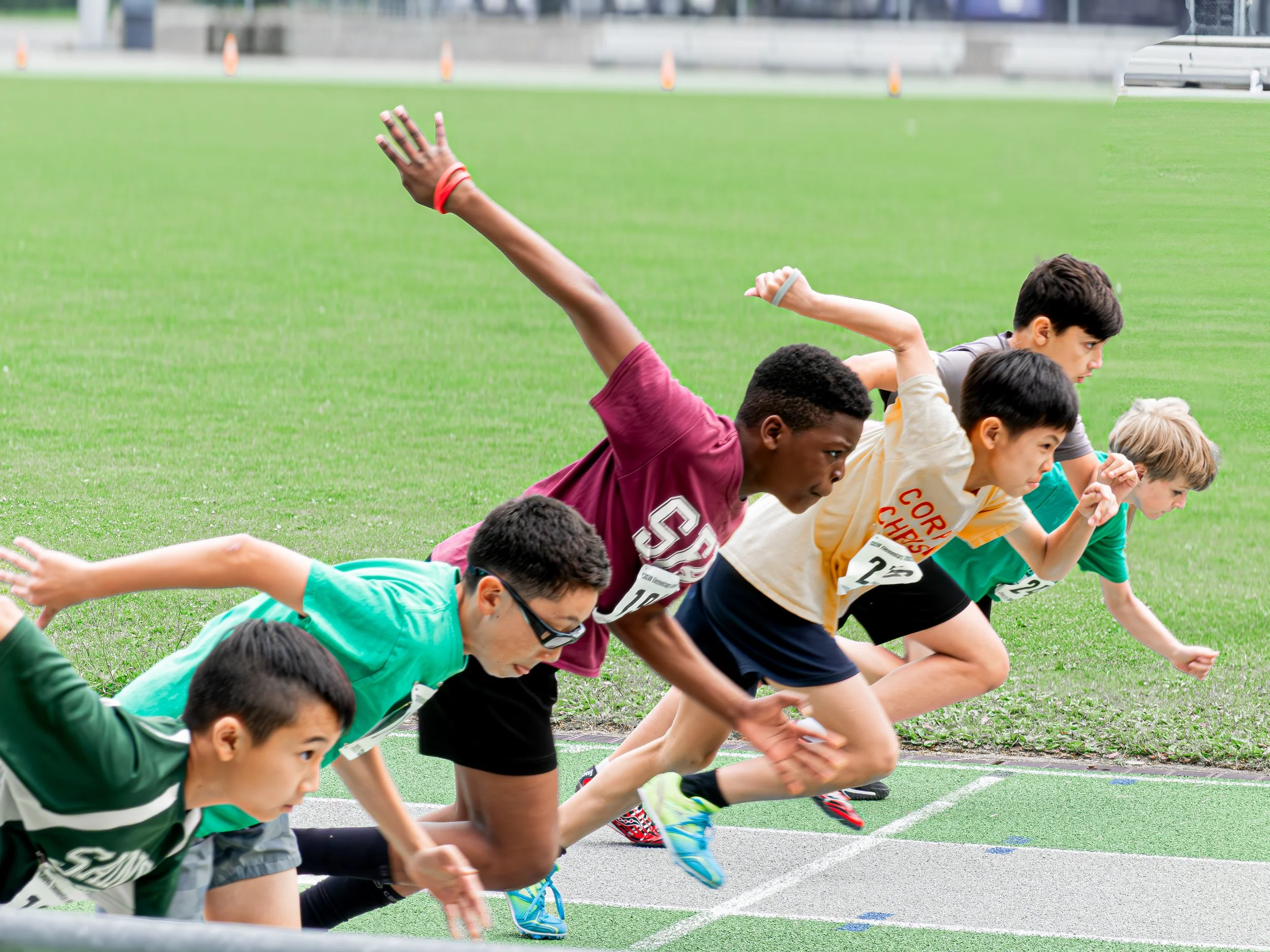 Young boys at the start of a running race on a track.