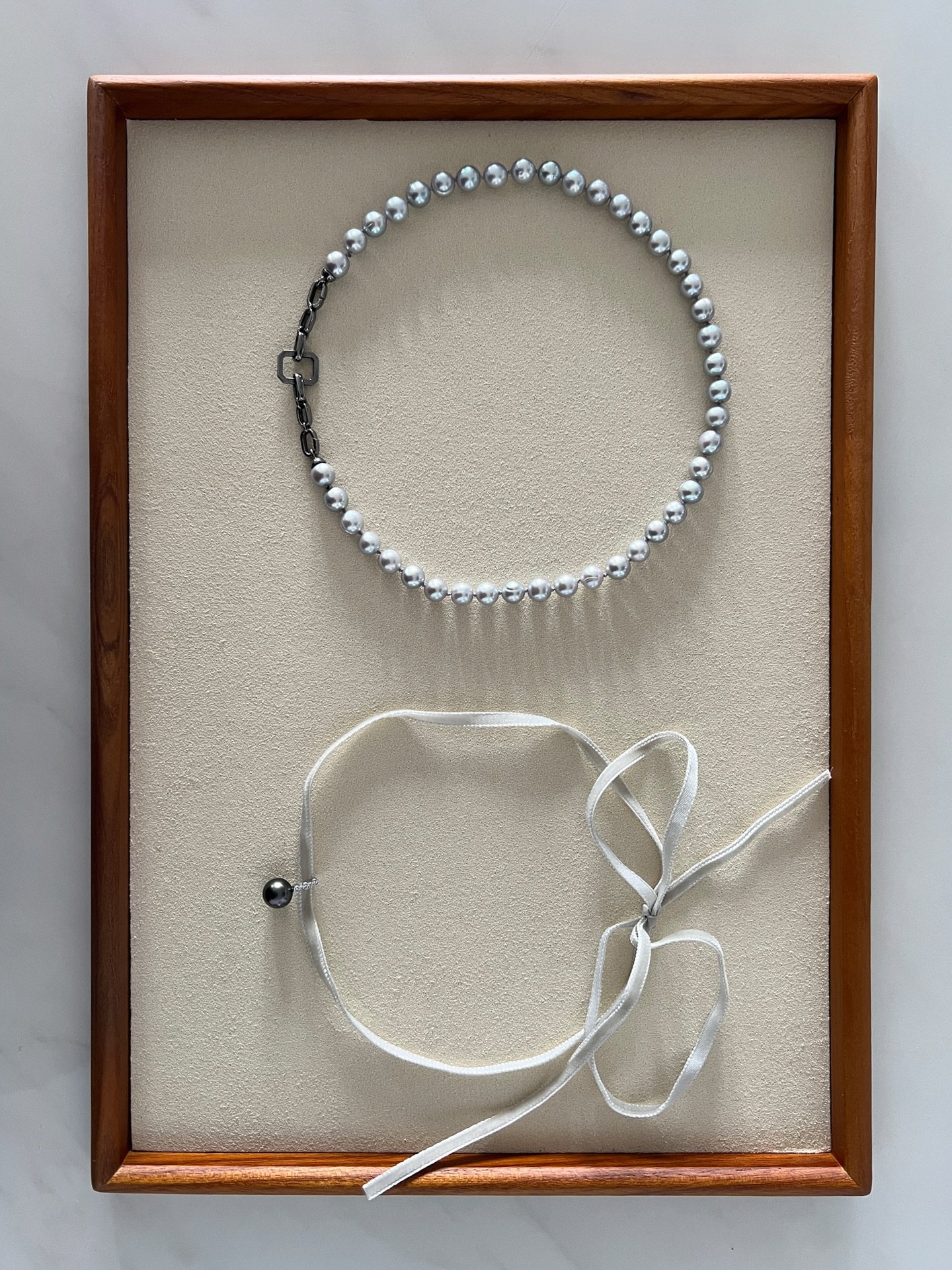 Two necklaces, two moods. 
1. A sleek choker crowned with a Tahitian pearl.
2. A classic strand with a twist: luminous sliver pearls with a substantial white gold chain.

Modern restraint meets timeless romance.
Wear them together. Wear them apart. N