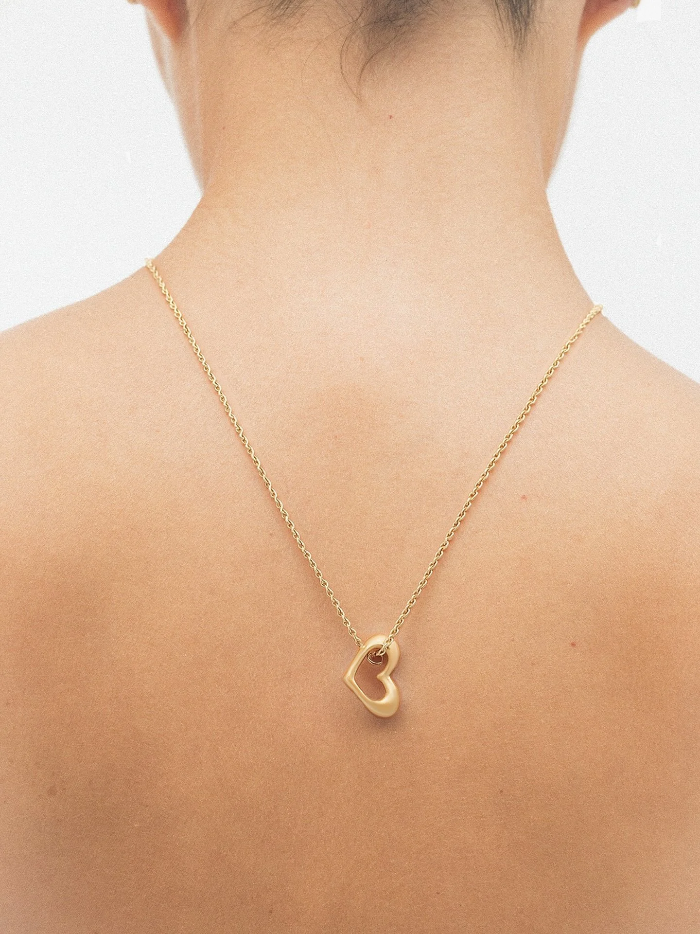 A heart &mdash; but not entirely obvious? 

The hefty gold heart pendant was designed and sculpted by hand in Madrid. Shaped slowly, curve by curve, until it felt both modern and familiar.

Soft but strong, slightly asymmetrical.
Romantic &mdash; wit