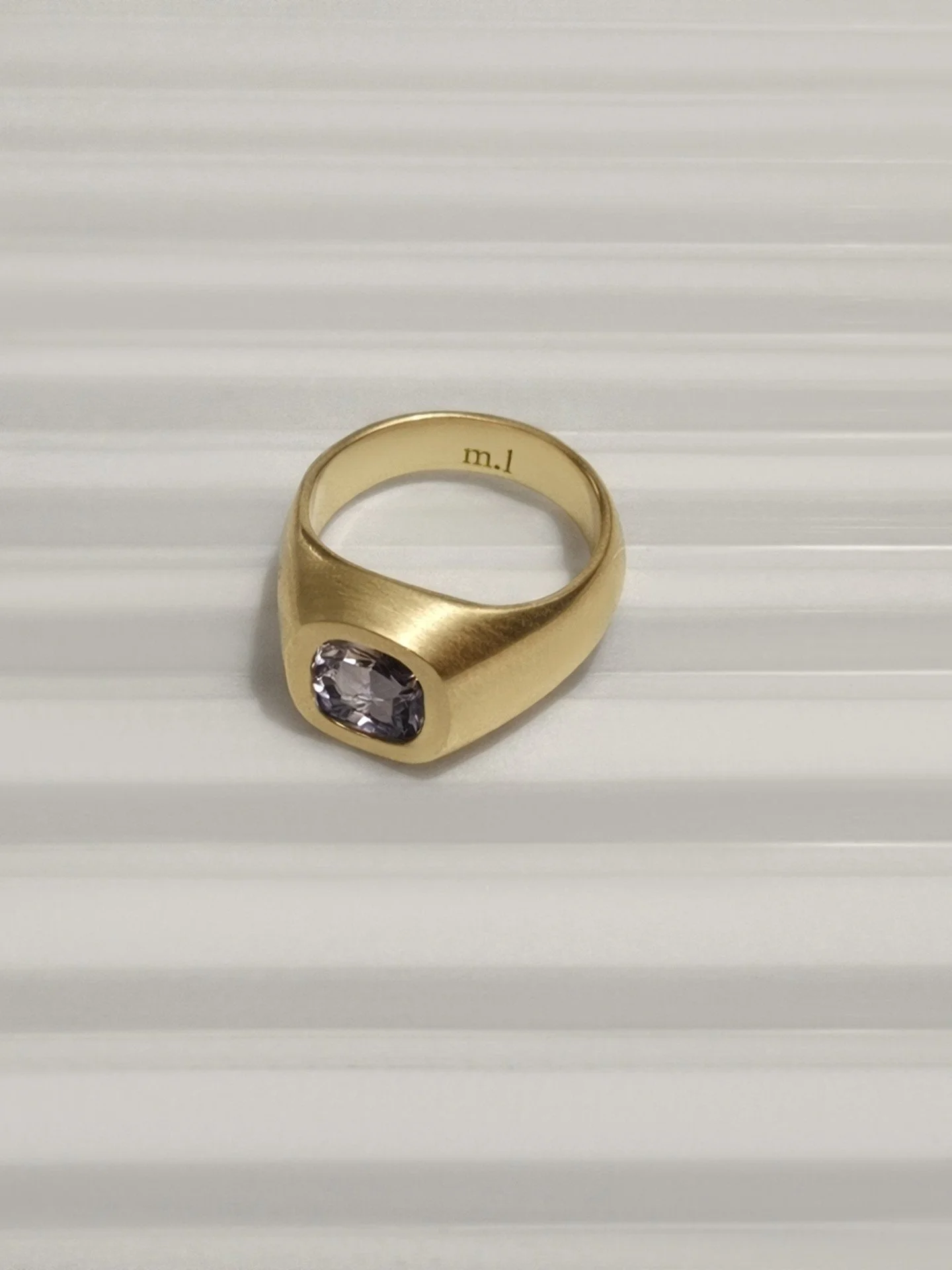 The colour of a sky just before it changes. Not quite blue, not quite grey
Something softer, harder to name.

Clouded spinel set in solid 9k gold. Rounded curves, a weight you feel from the first moment. A quiet statement, worn close. Choose from sha