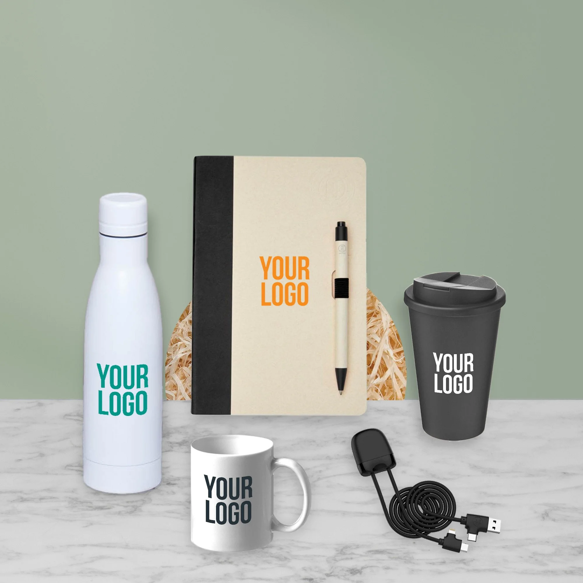Example branded merchandise for corporate hampers including a notebook, bottle, reusable cup, mug and tech accessory.