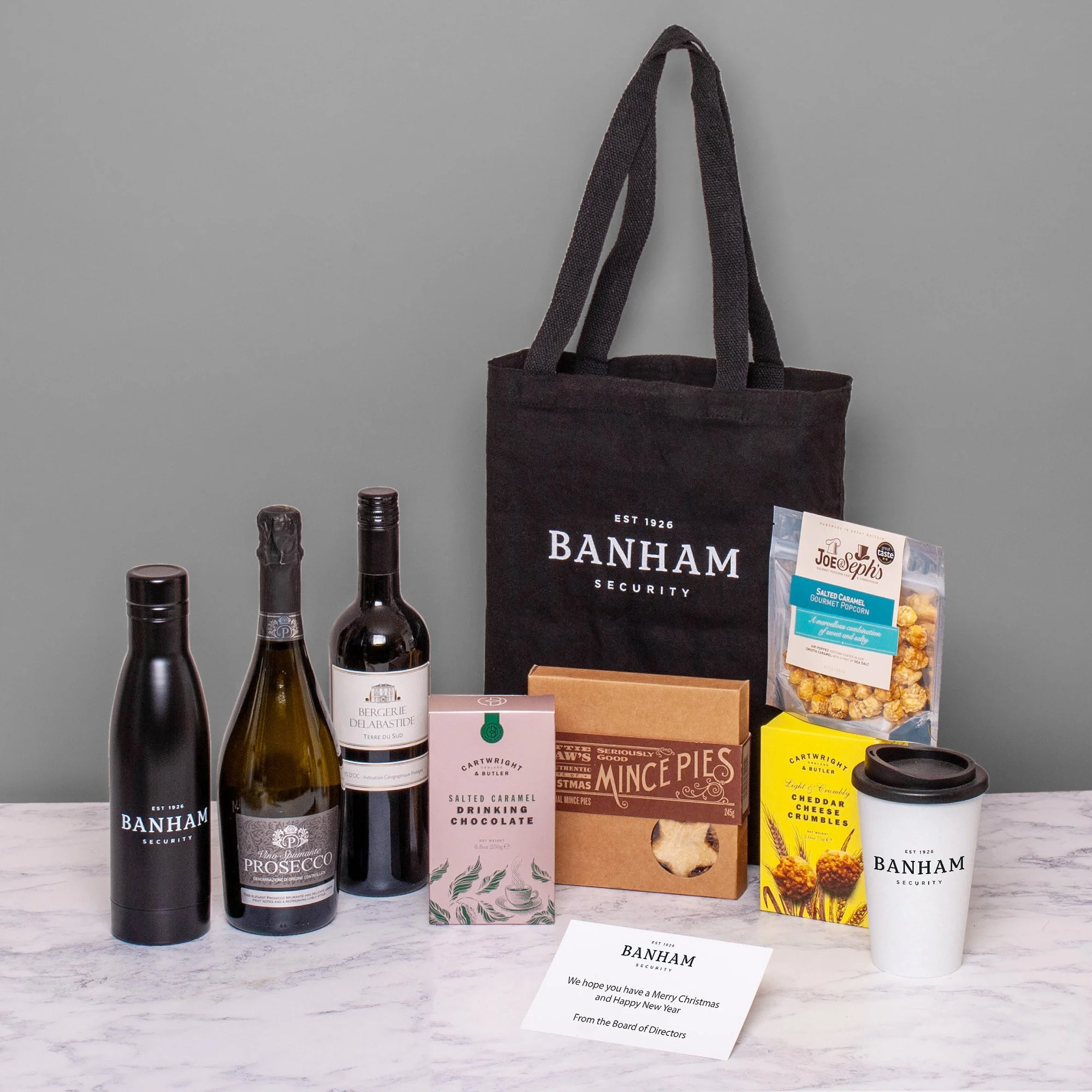 Bespoke Branded Festive Gift Bag with Prosecco, Wine, Sweet & Savoury Treats and Branded Water Bottle & Travel Cup, for Banham Security. 