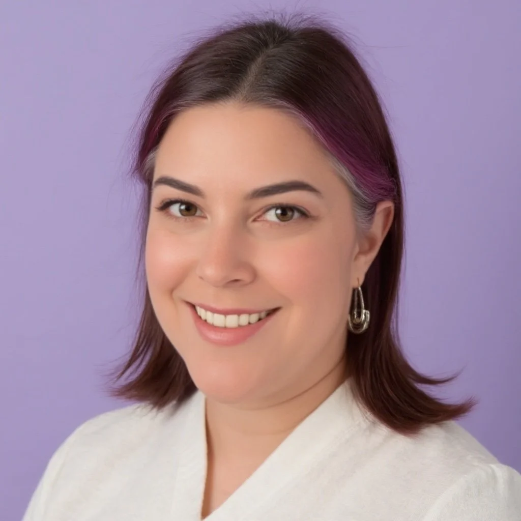 Smiling person with short, dark hair wearing a white shirt against a purple background.