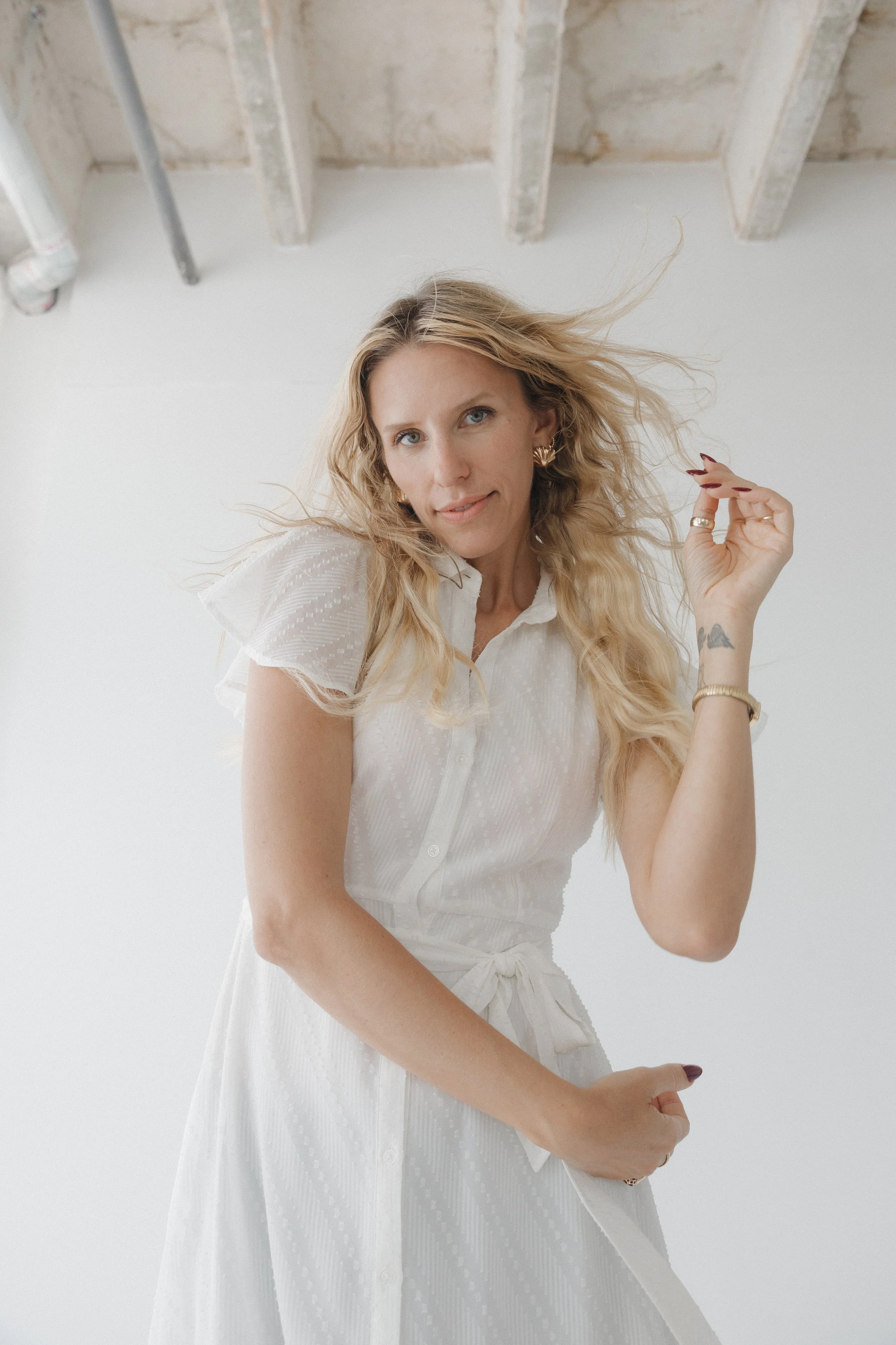 Blonde woman in angelic white dress with long hair.