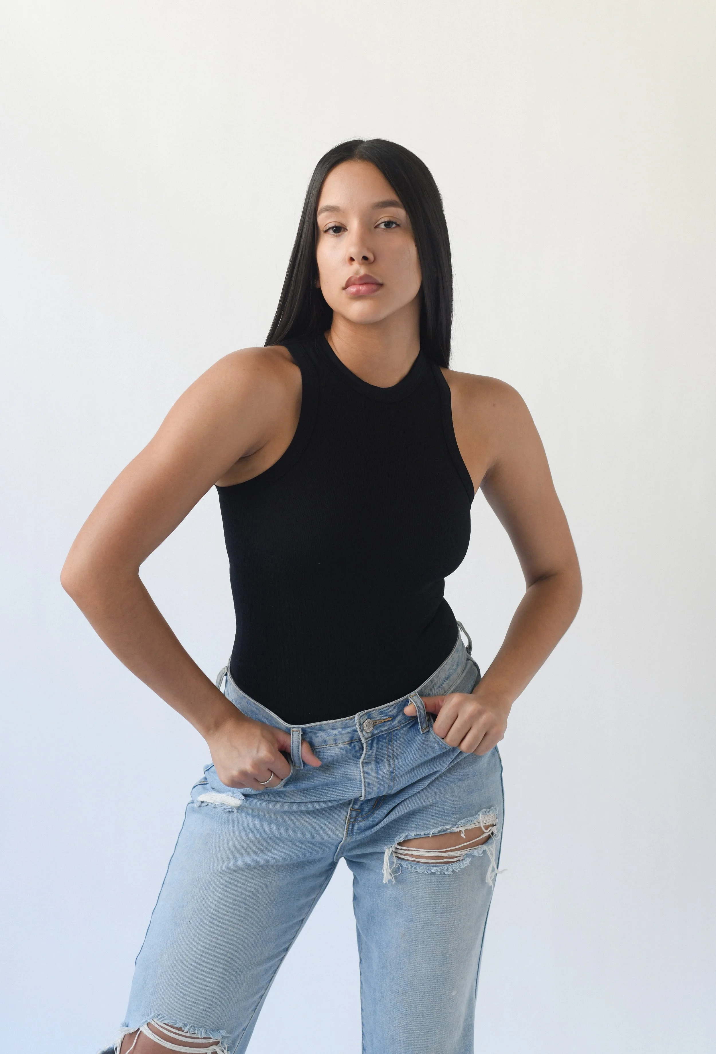 Woman in jeans posing in a black tank top