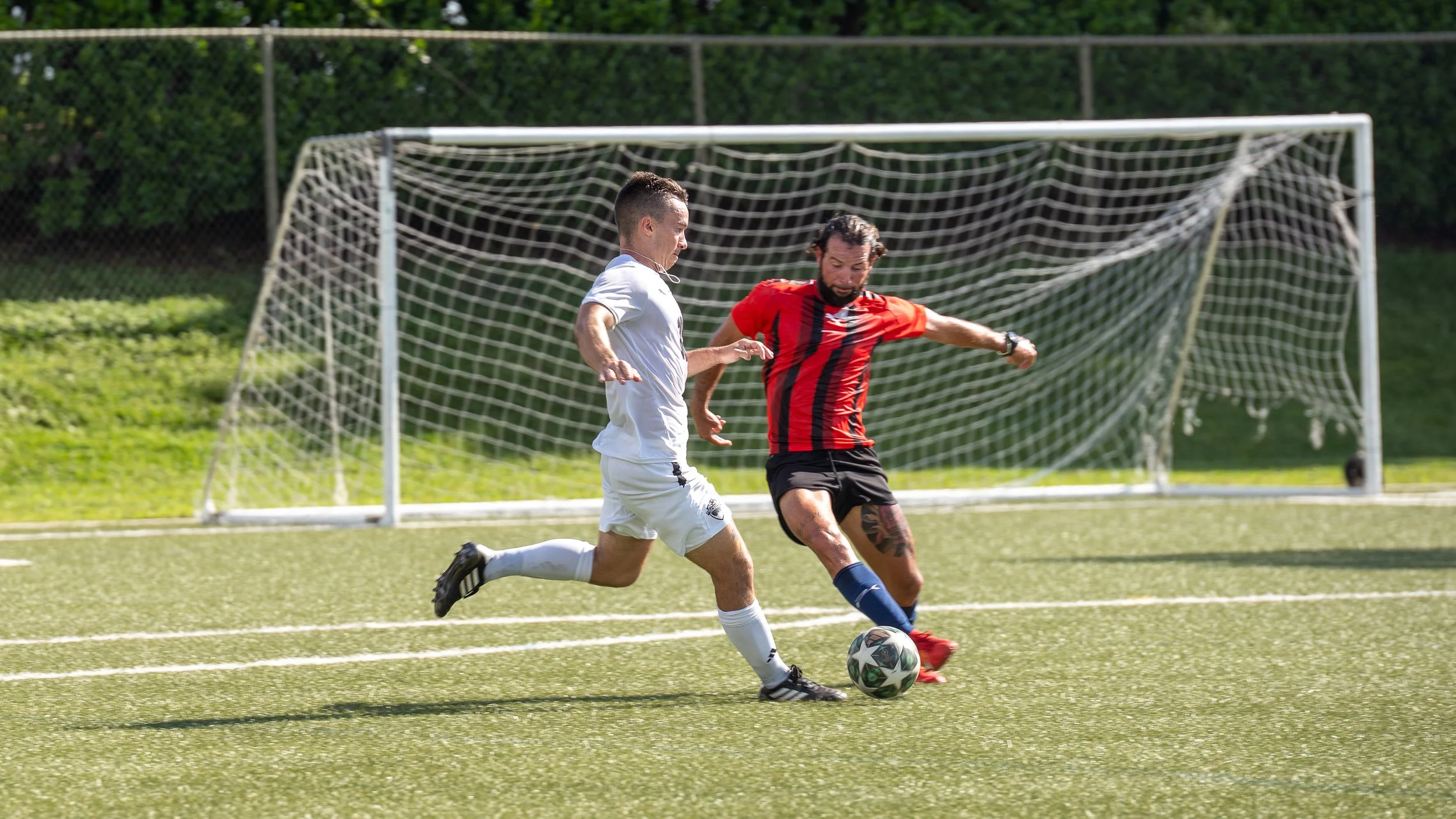 Couple walking on the beach, woman holding a sign announcing pregnancy, text reading "Baby Dozzo Coming Soon December 2024."