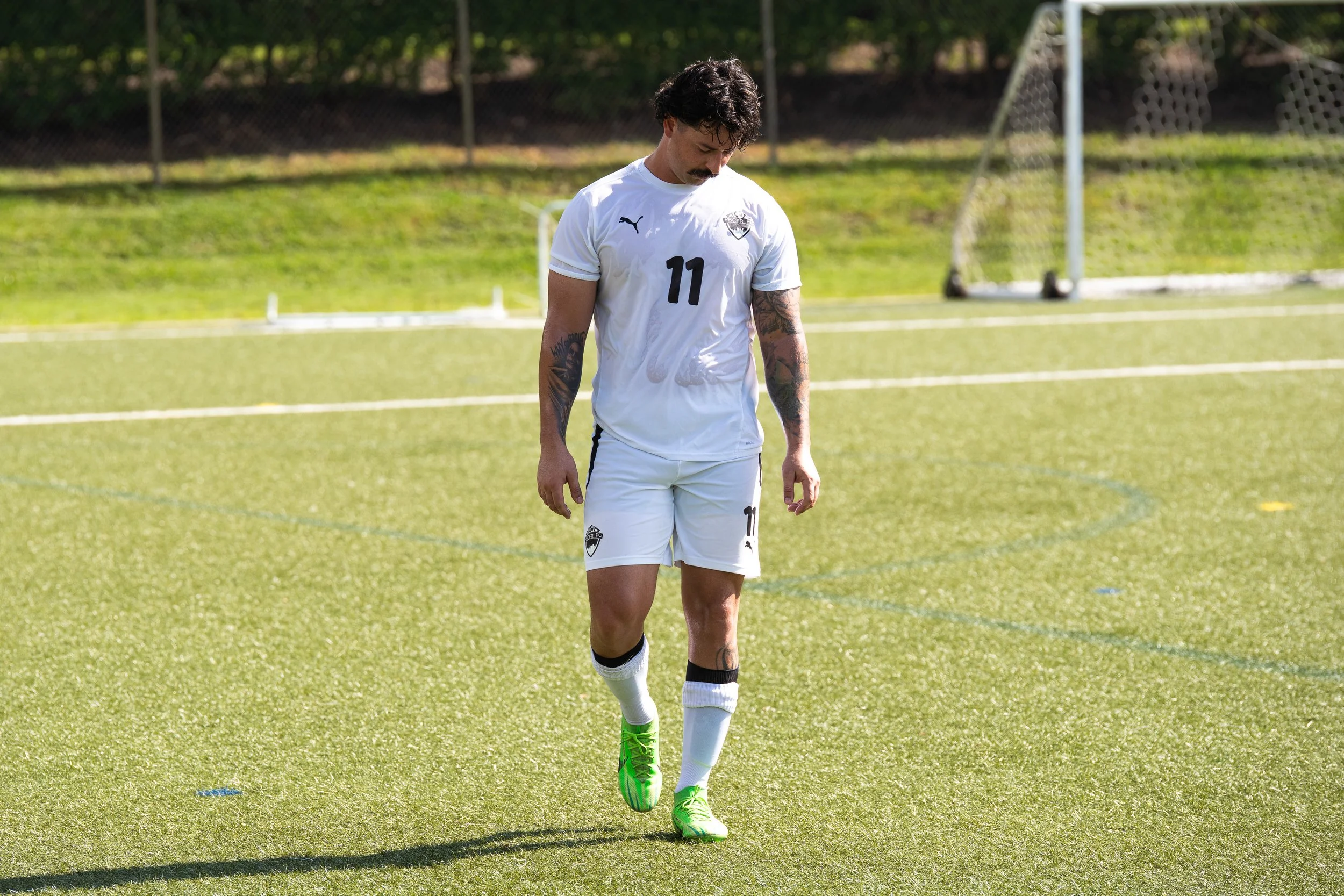 A couple holding hands walking on a beach at sunset.