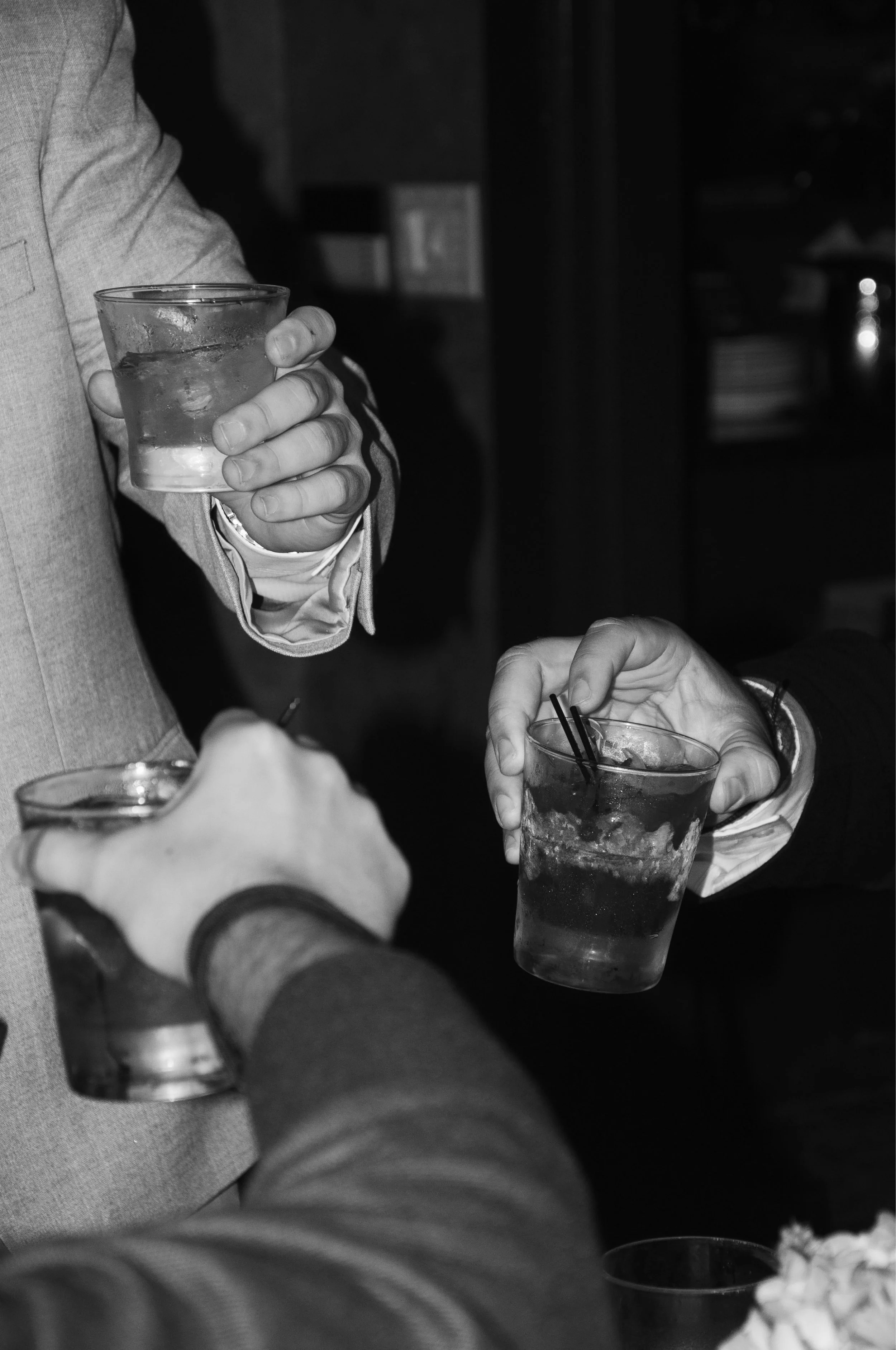 Three people toasting with drinks in a glass.